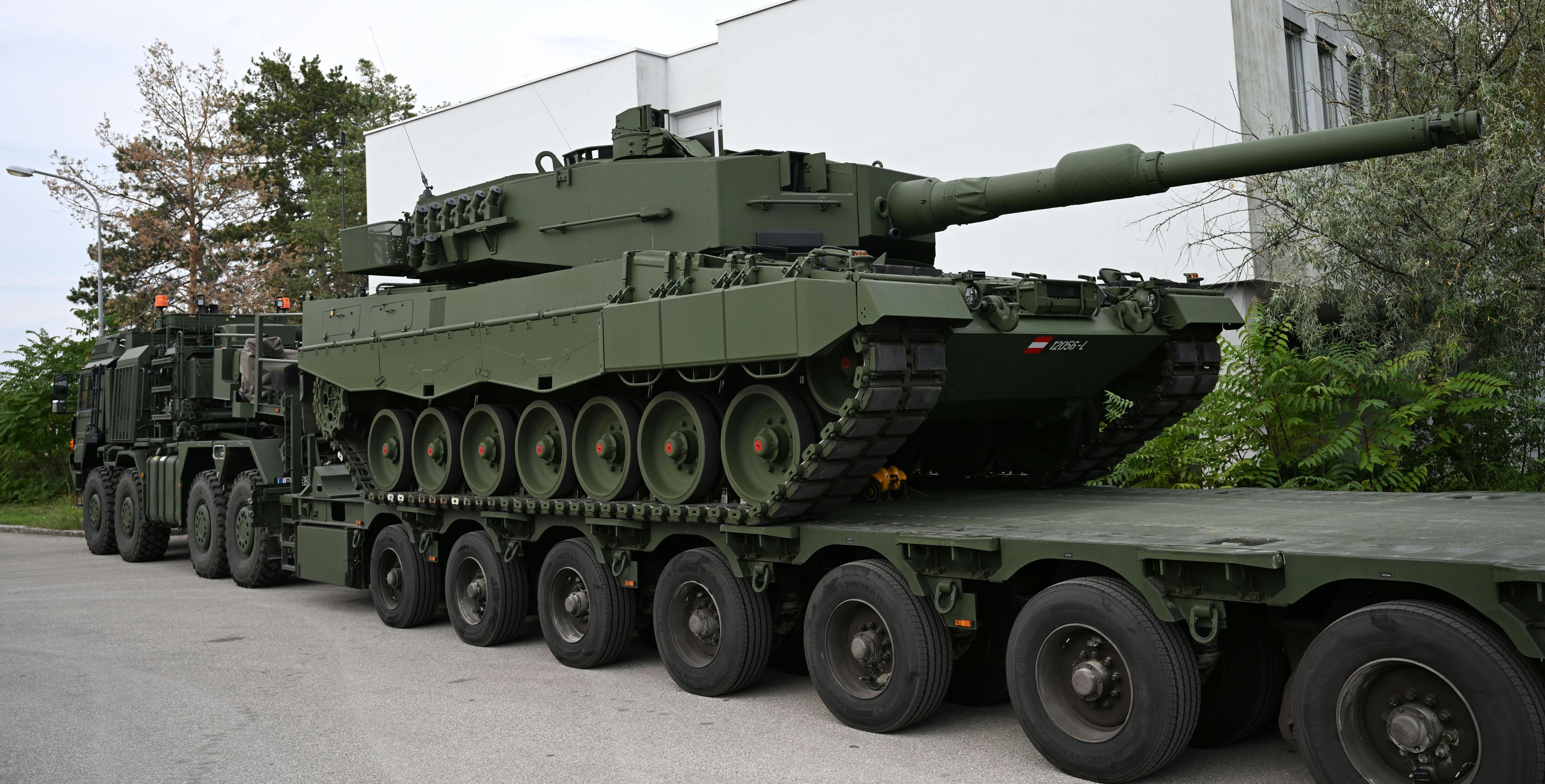 Ein Leopard 2A4 Kampfpanzer wird auf einem Militärtransporter vor einer Kaserne transportiert.