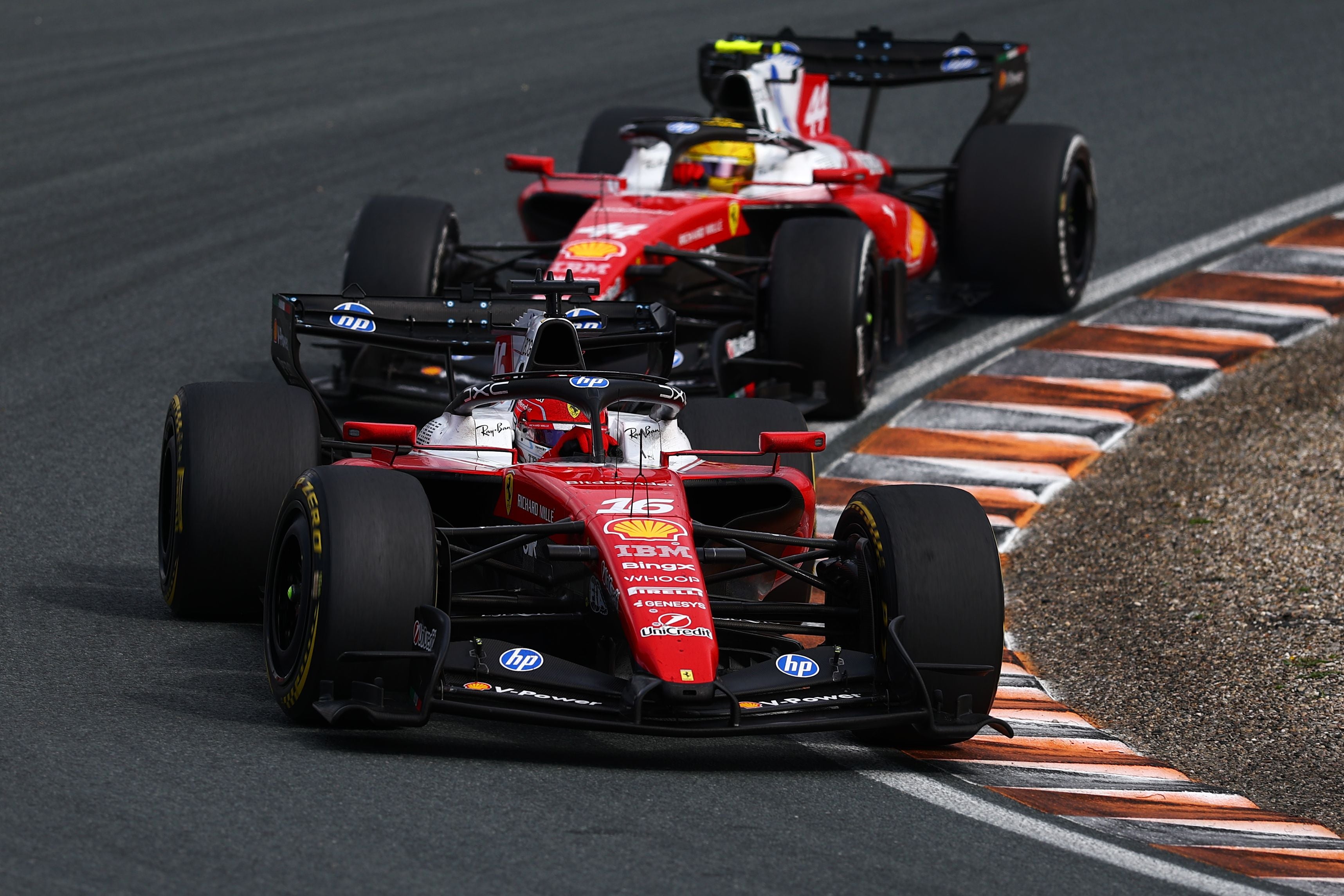 Zwei Ferrari Formel-1-Autos fahren nebeneinander durch eine Kurve auf der Rennstrecke Zandvoort.