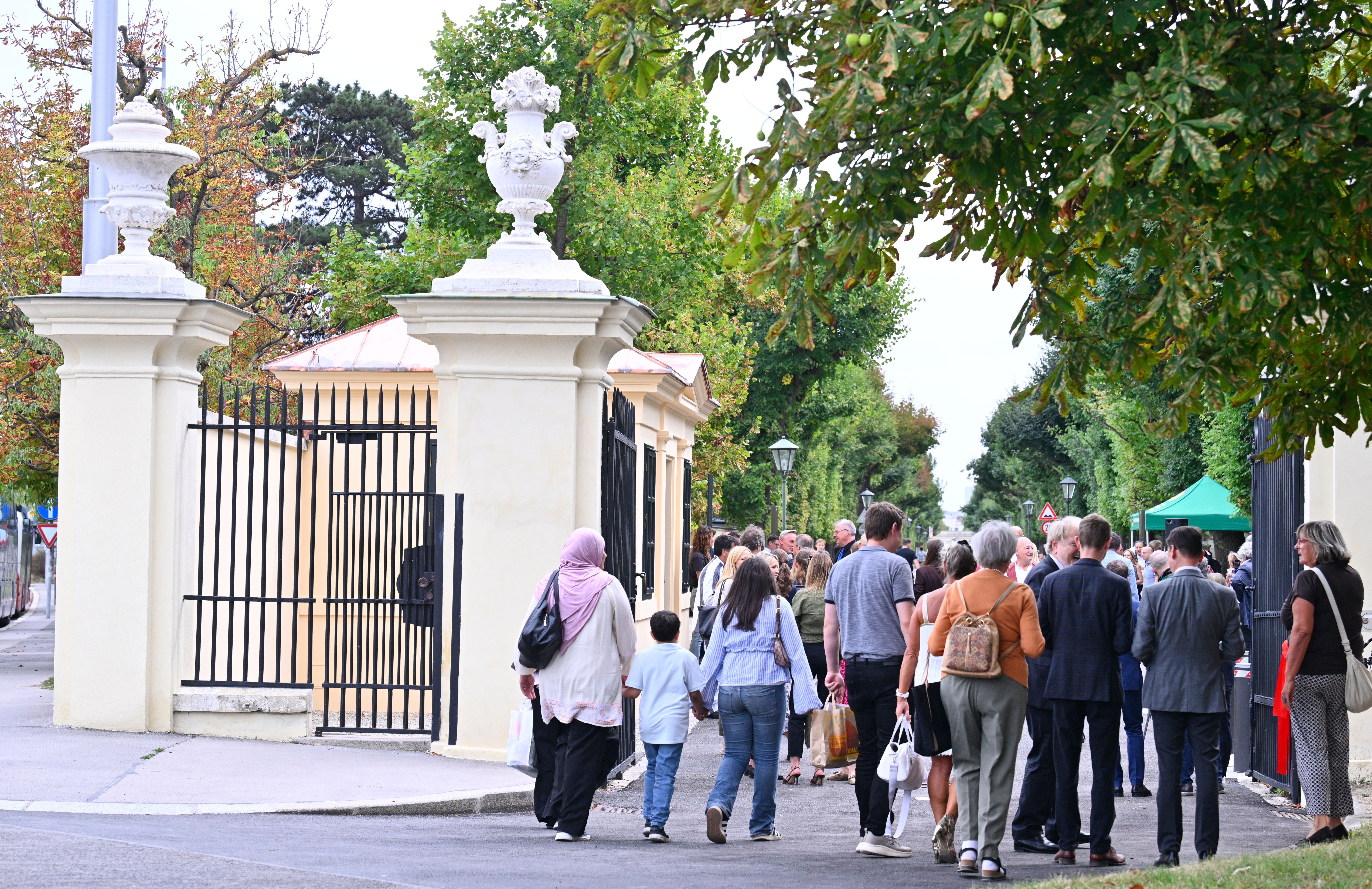Menschenmenge betritt das Engelstor zum Schlosspark Schönbrunn bei einer feierlichen Eröffnung.