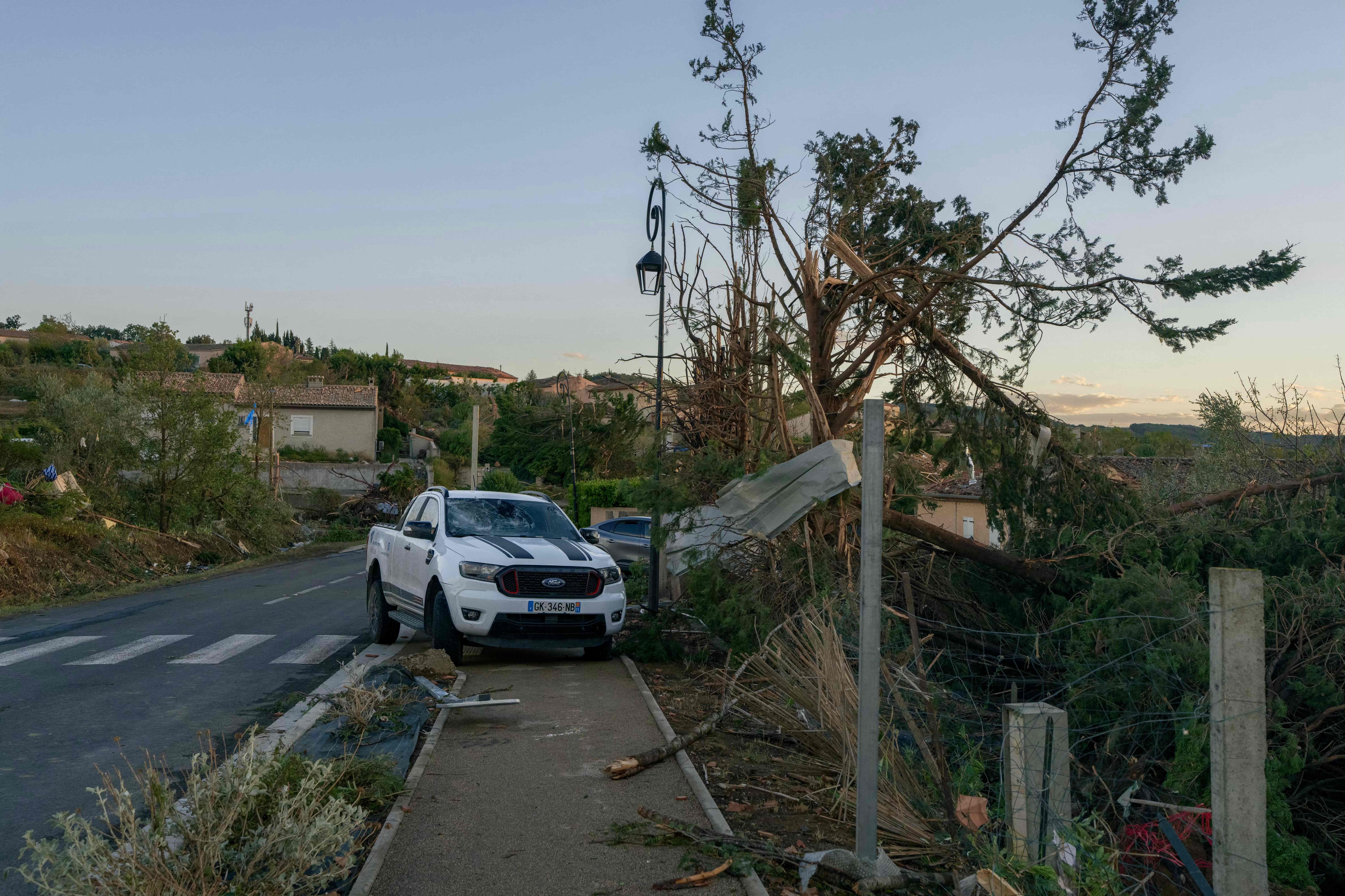 Ein beschädigtes Auto steht neben umgestürzten Bäumen und Trümmern nach einem Tornado in Pomas.