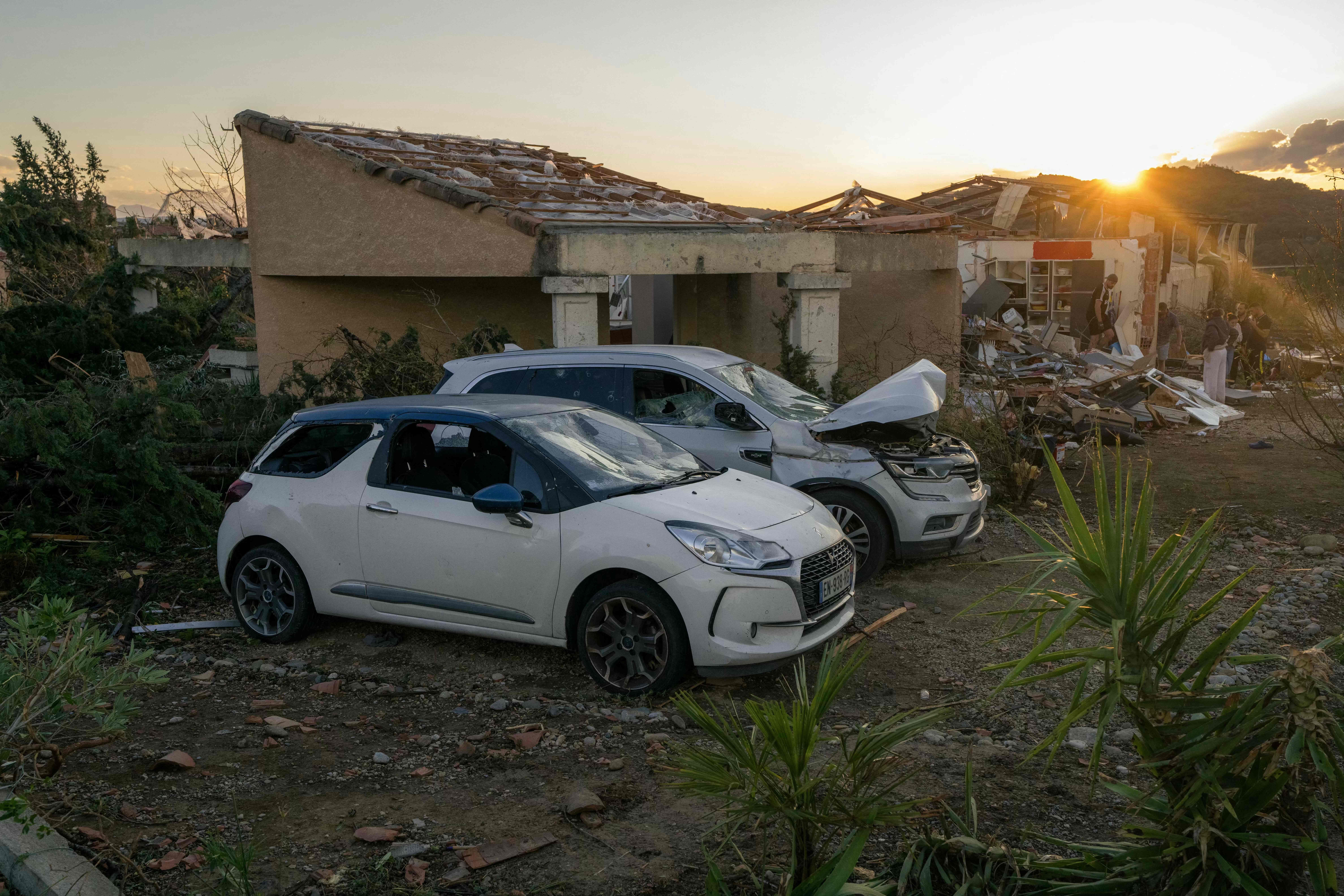 Zerstörte Autos und Häuser nach einem Tornado in Pomas, Südwestfrankreich, bei Sonnenuntergang.