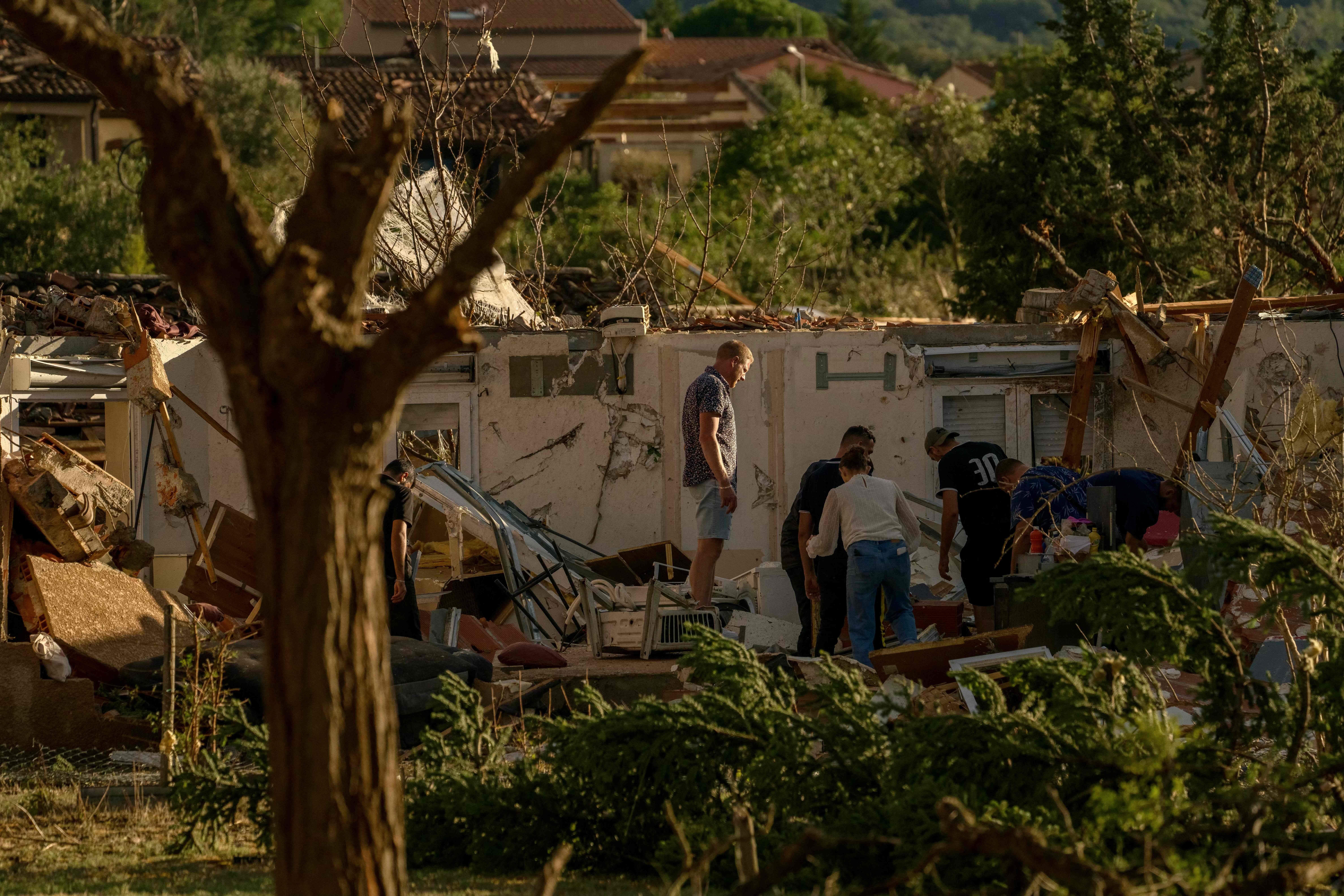 Menschen durchsuchen Trümmer eines zerstörten Hauses nach einem Tornado in Südwestfrankreich.