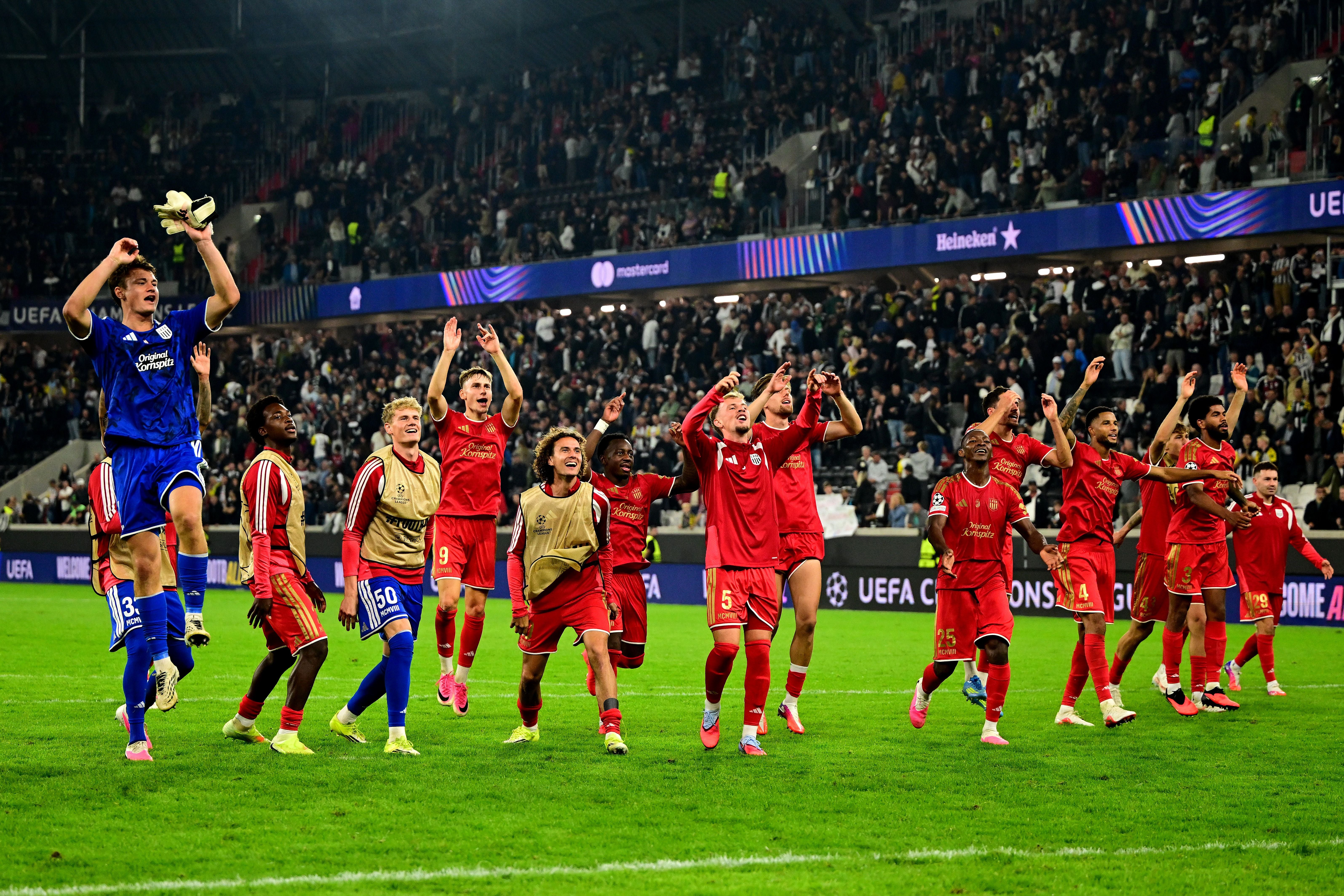 LASK-Spieler jubeln auf dem Spielfeld vor jubelnden Fans nach einem UEFA Champions League-Spiel.