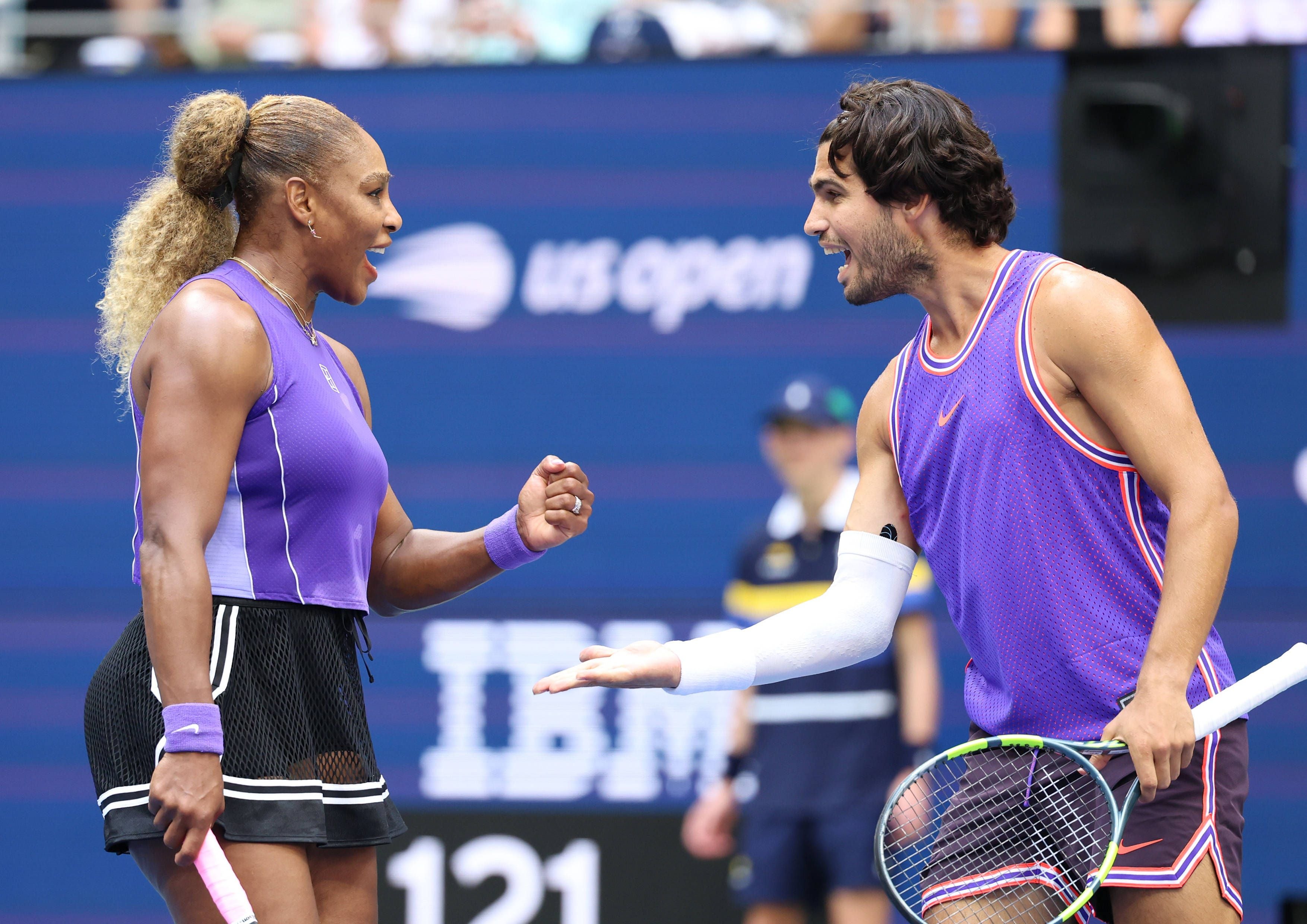 Serena Williams und ein männlicher Spieler jubeln gemeinsam auf dem Tennisplatz bei den US Open.