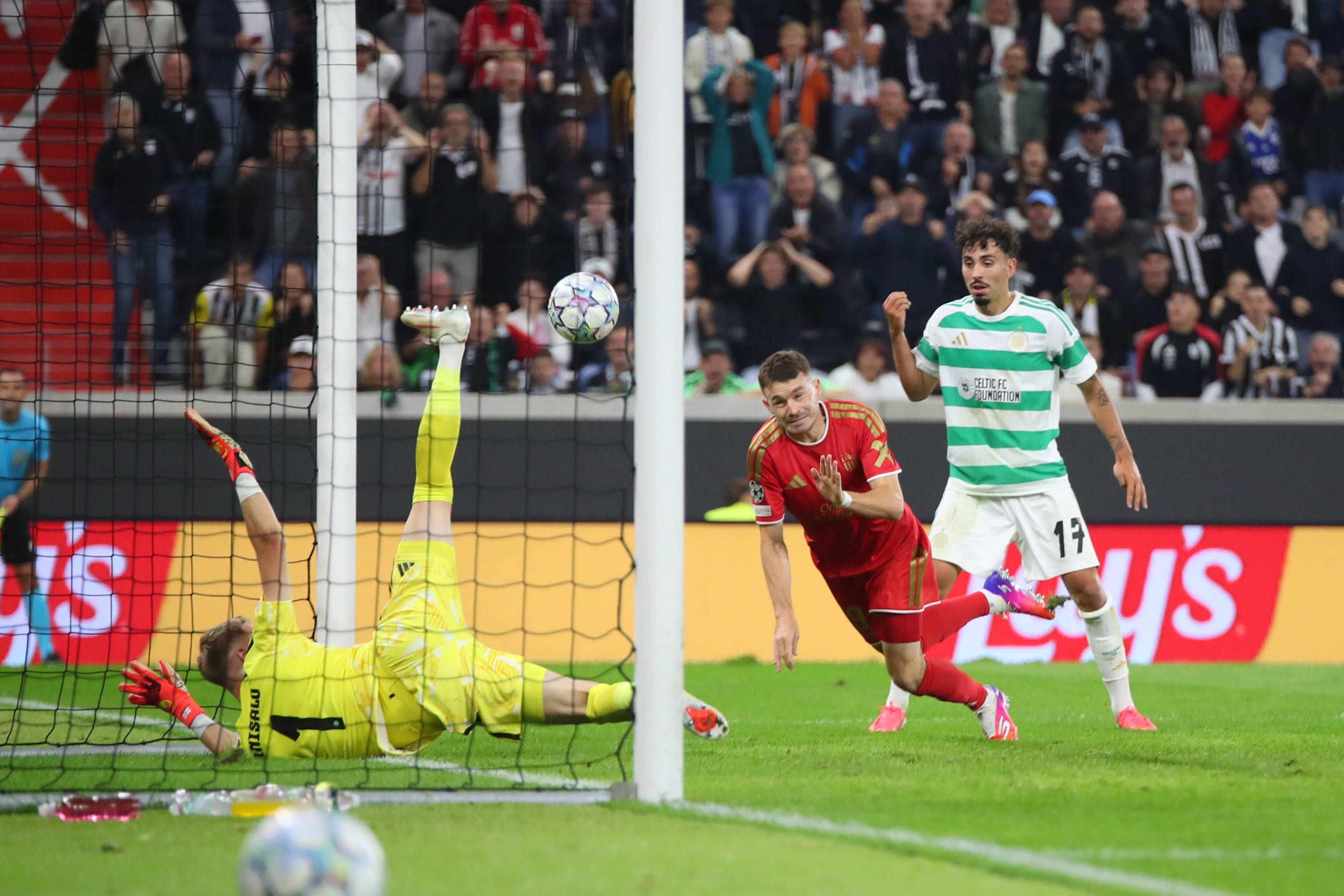 Ein Tor fällt beim Fußballspiel zwischen LASK (rot) und Celtic Glasgow (grün-weiß) vor Zuschauern.