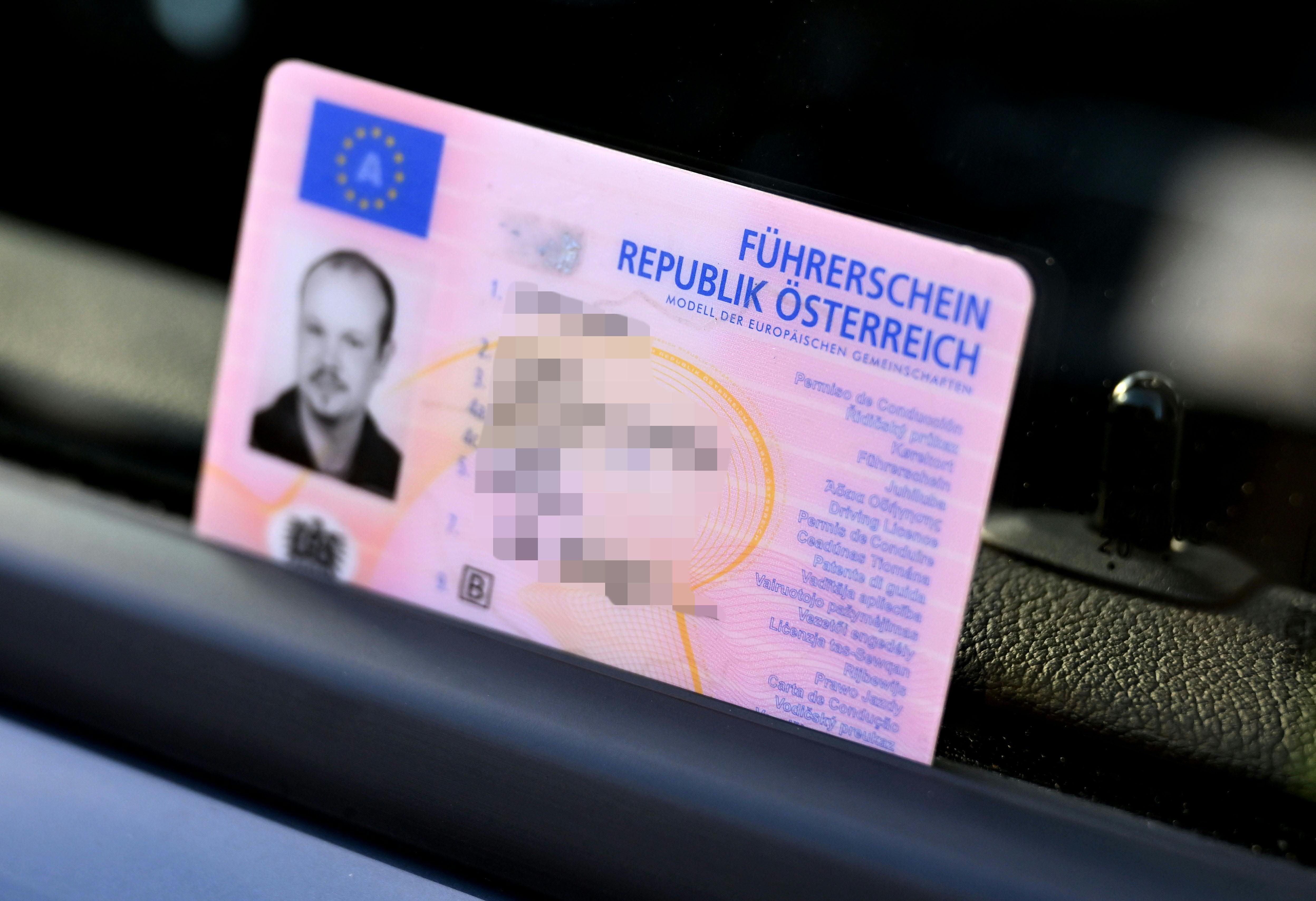 Österreichischer Scheckkartenführerschein liegt auf einem Armaturenbrett im Auto.