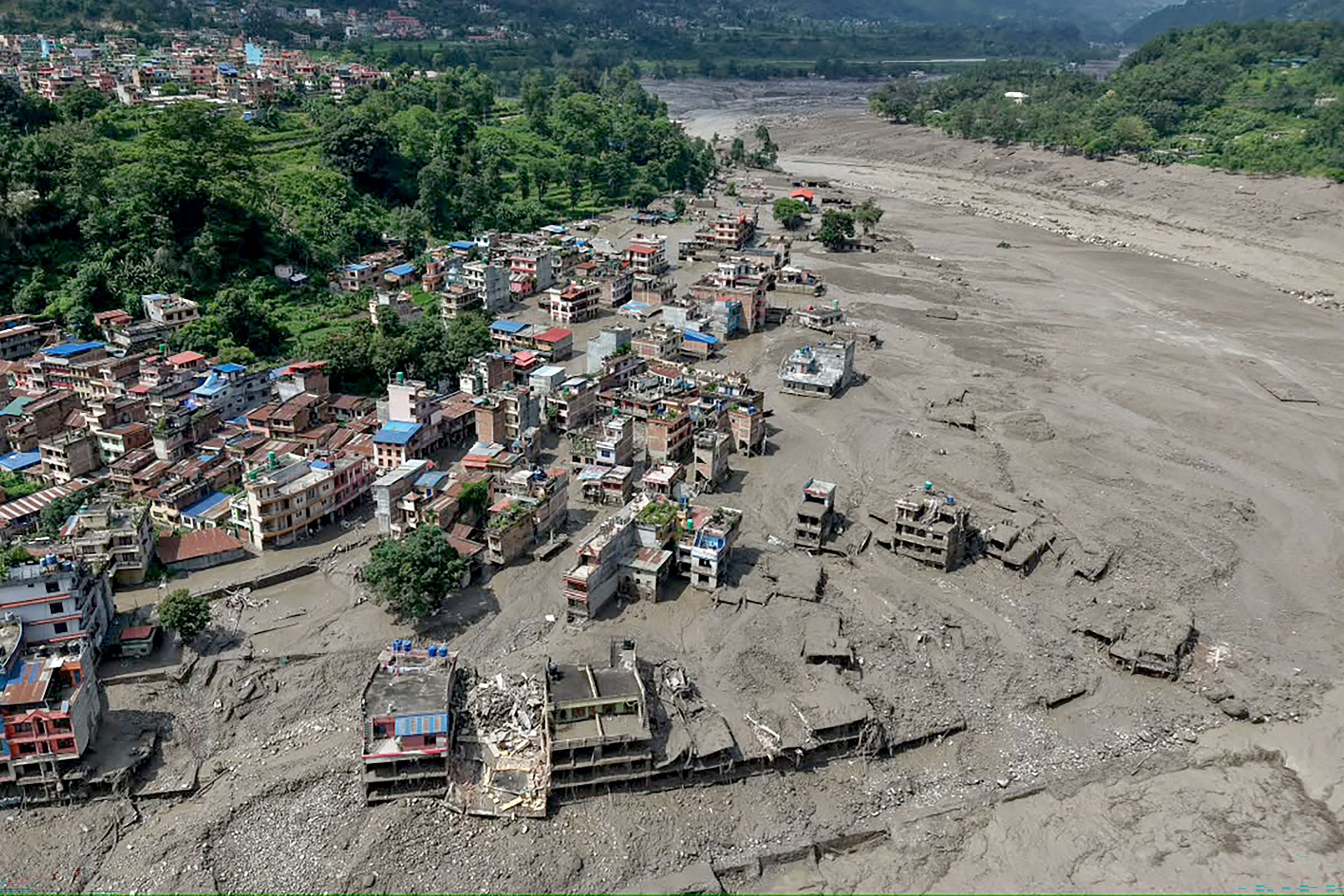 Überflutete und beschädigte Häuser am Flussufer nach einer Sturzflut in Nepal.