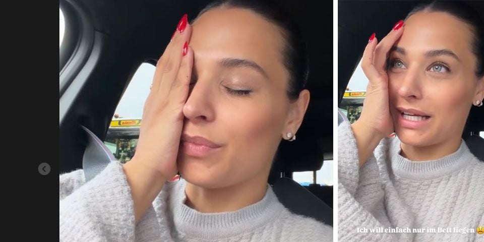 Frau im Auto hält sich das Gesicht, sieht müde oder gestresst aus.