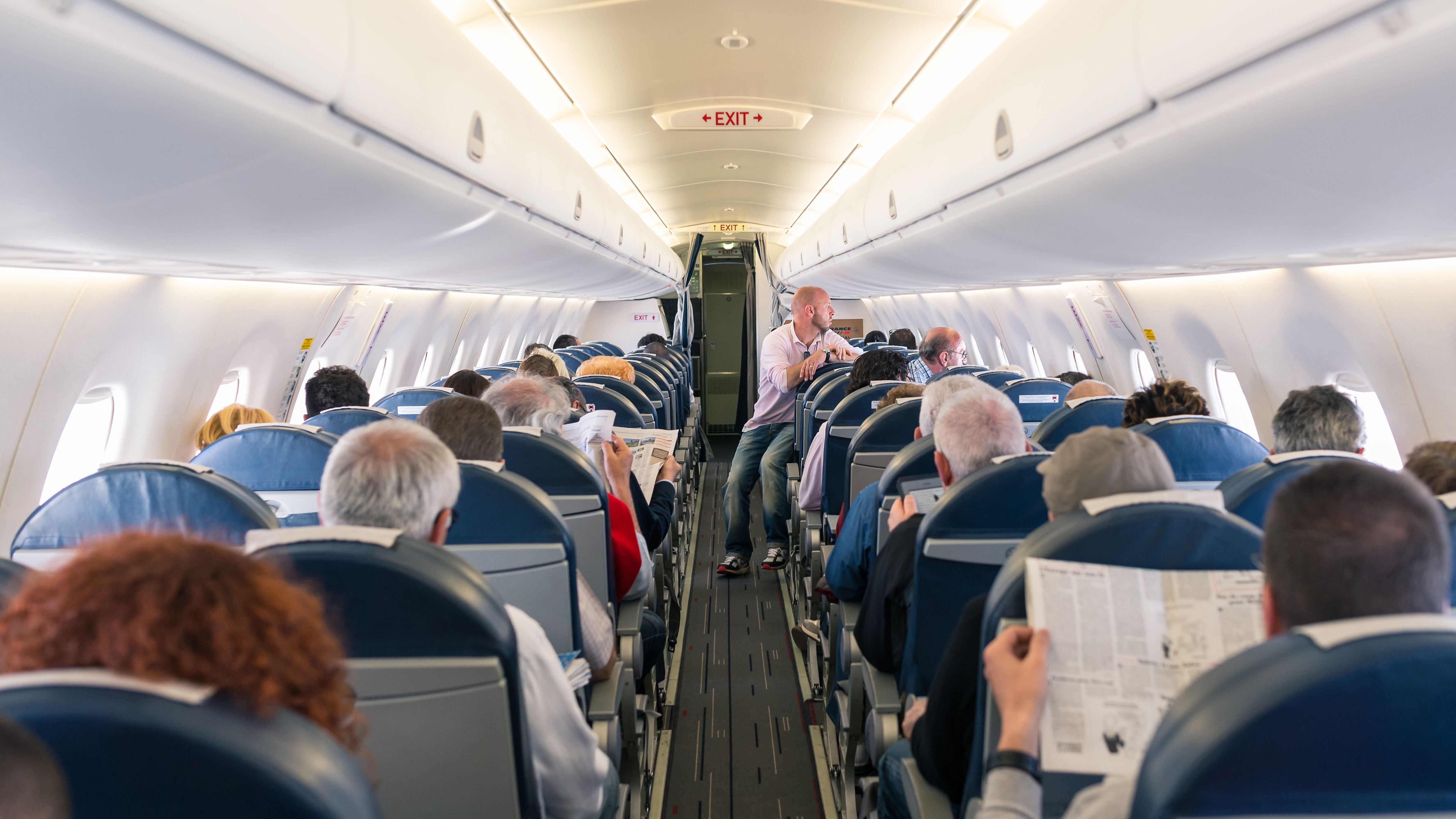 Passagiere sitzen im Flugzeug und lesen Zeitungen während des Fluges.