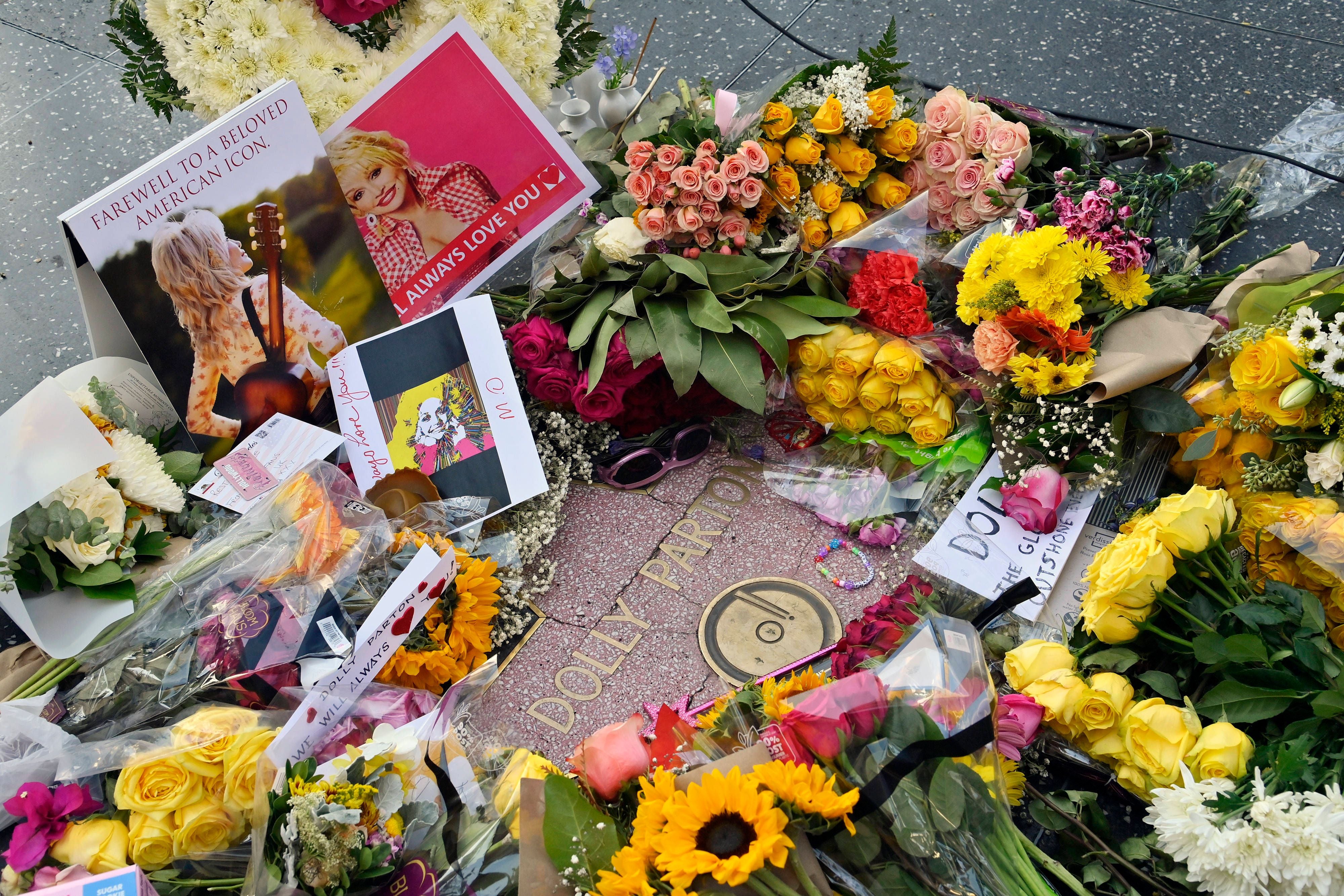 Viele Blumen, Karten und Fotos liegen als Tribut auf Dolly Partons Stern am Walk of Fame.