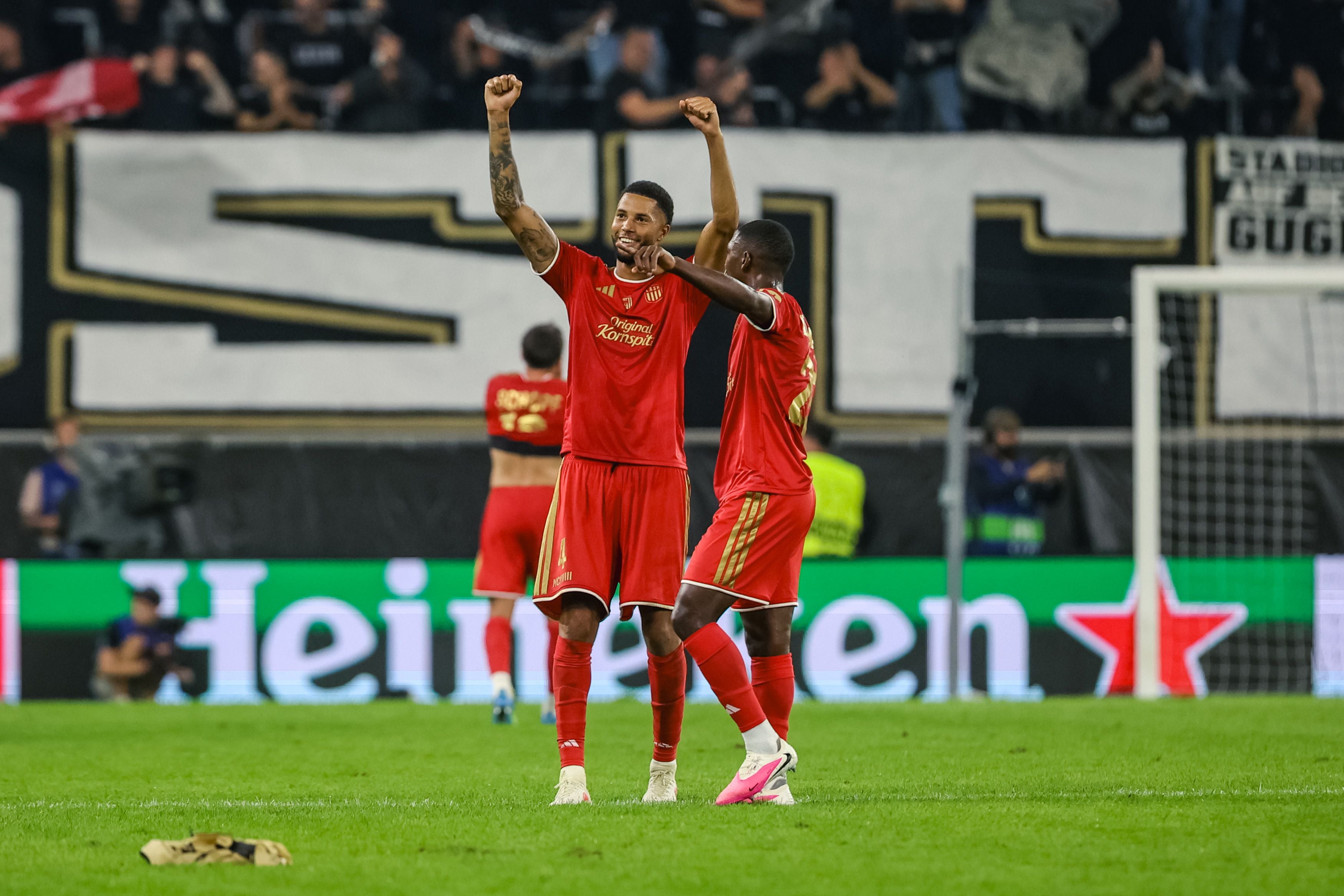 Zwei LASK-Spieler jubeln auf dem Fußballfeld nach einem UEFA-Champions-League-Spiel.