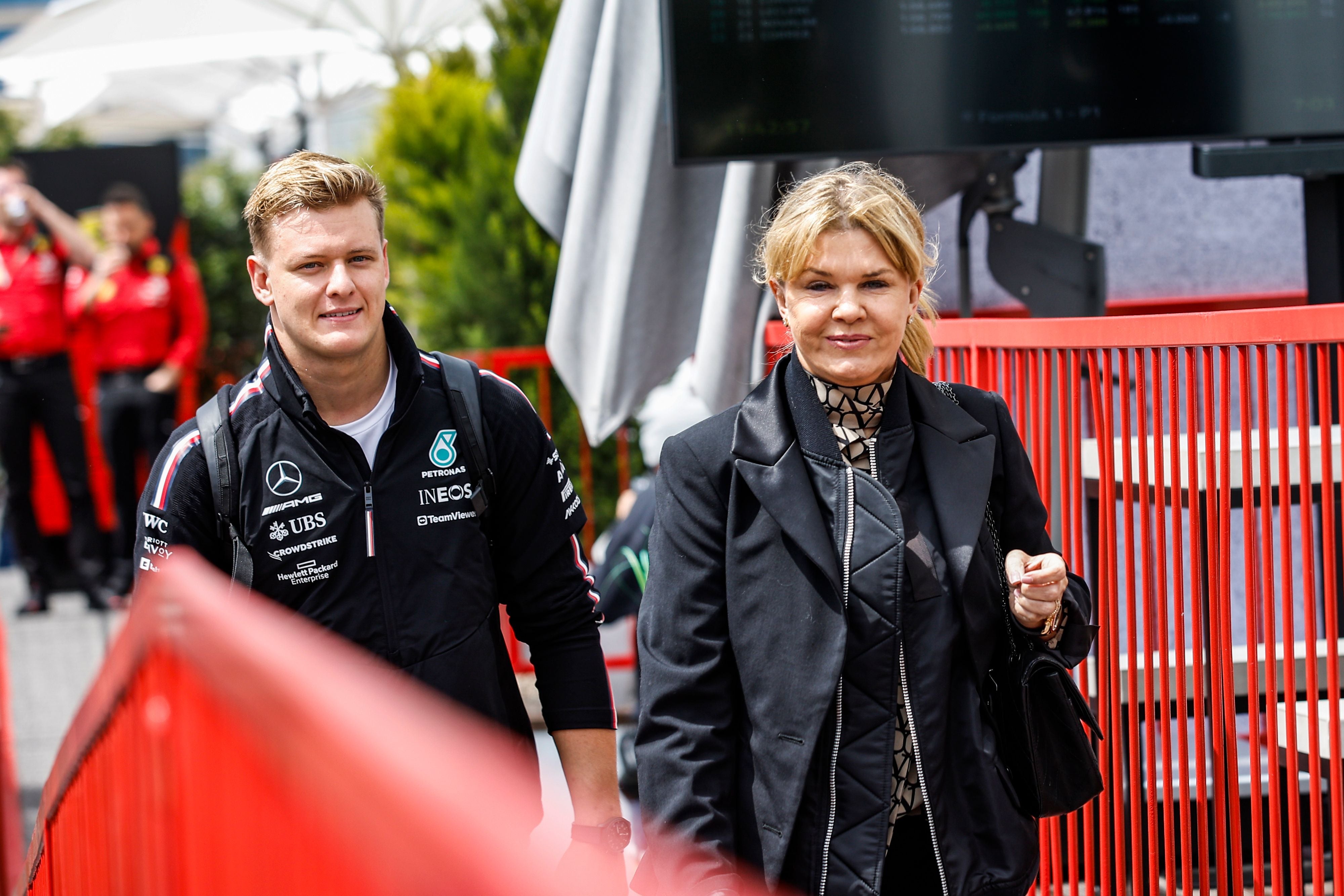 Zwei Personen gehen neben einem roten Geländer bei einem Formel-1-Event in Baku, Aserbaidschan.