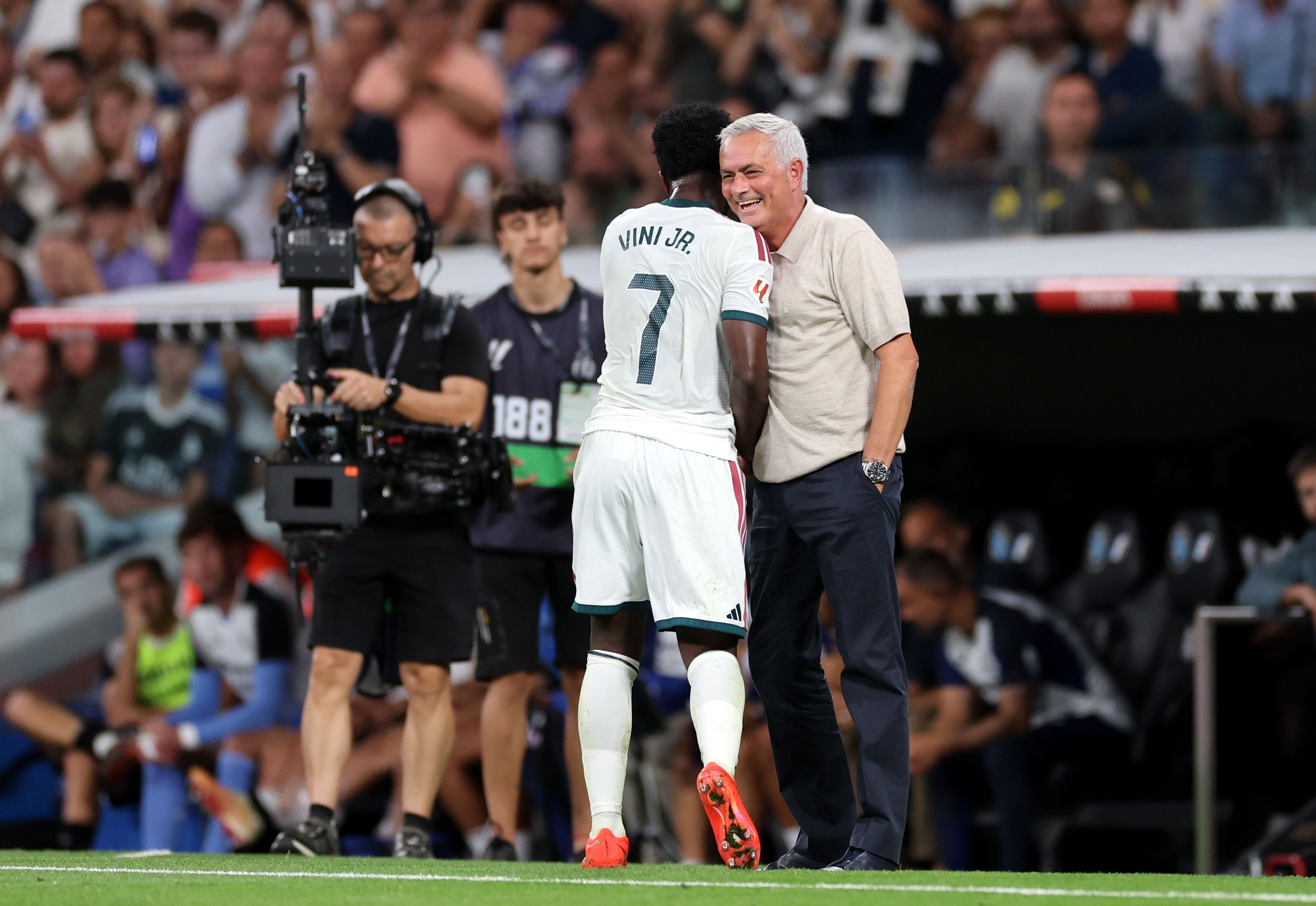 Vinicius Junior spricht mit seinem Trainer an der Seitenlinie während eines Fußballspiels.