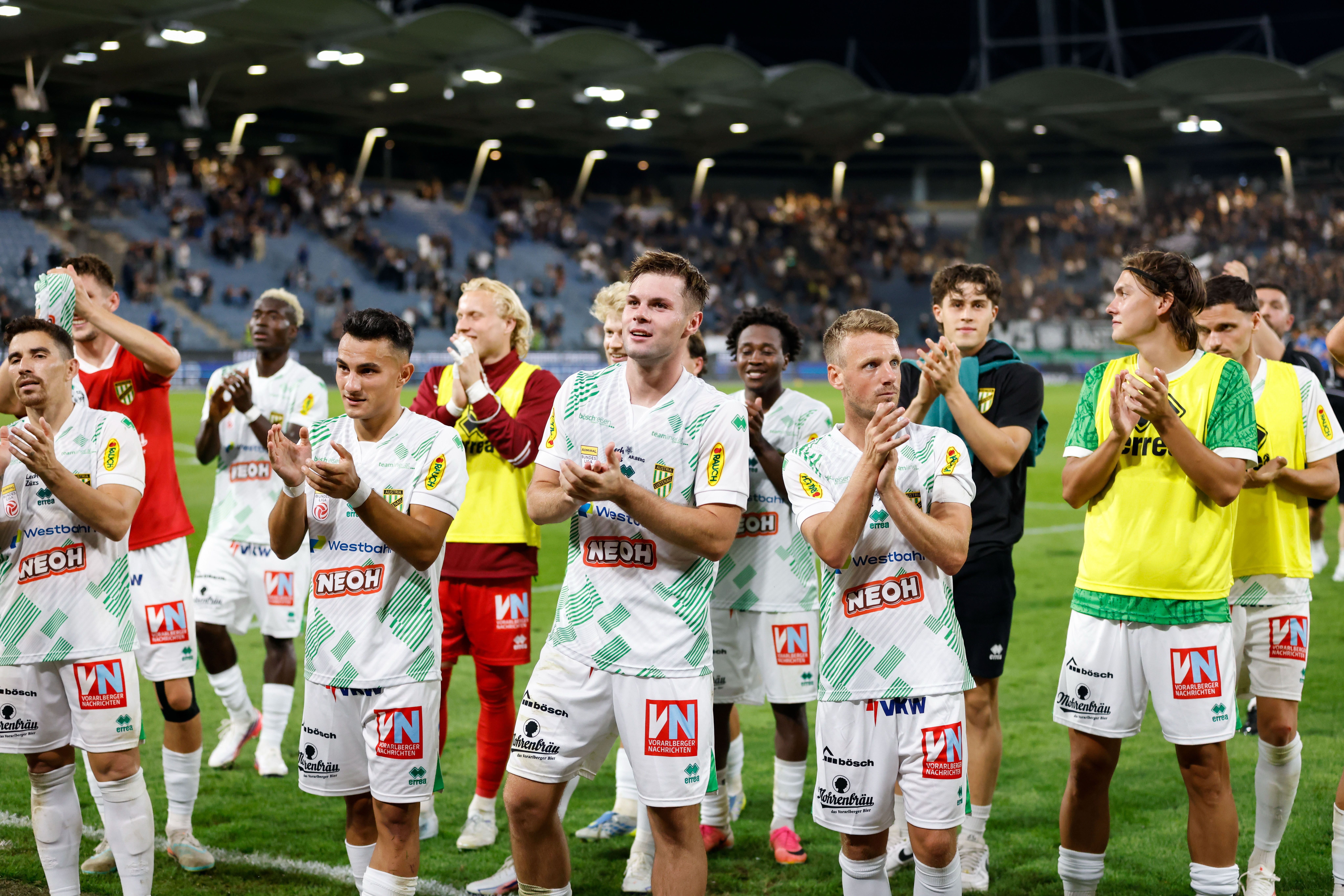 Spieler des SC Austria Lustenau jubeln und klatschen nach einem Fußballspiel im Stadion.