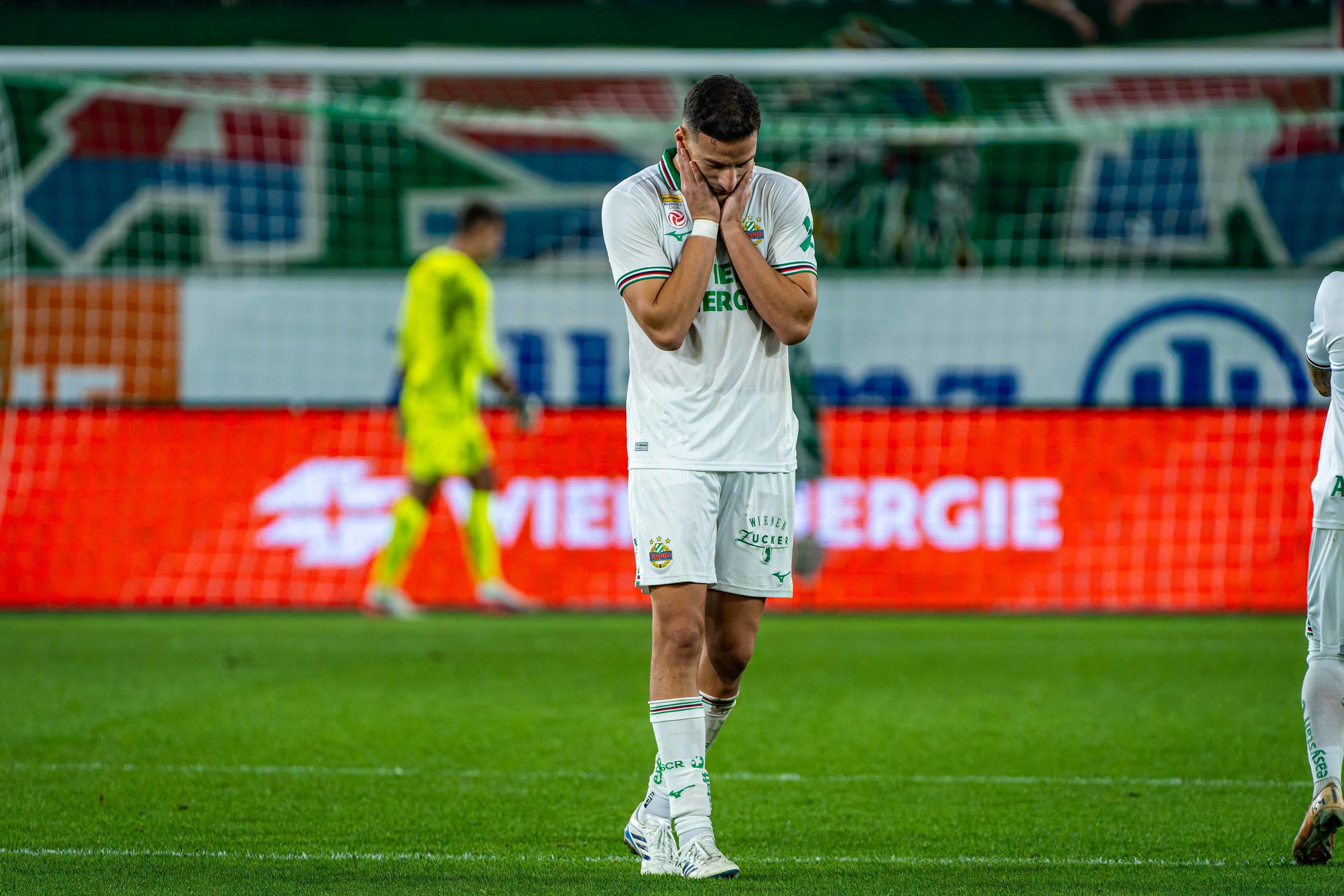 Fußballspieler von Rapid Wien zeigt Enttäuschung nach einem Elfmeterschießen auf dem Spielfeld.