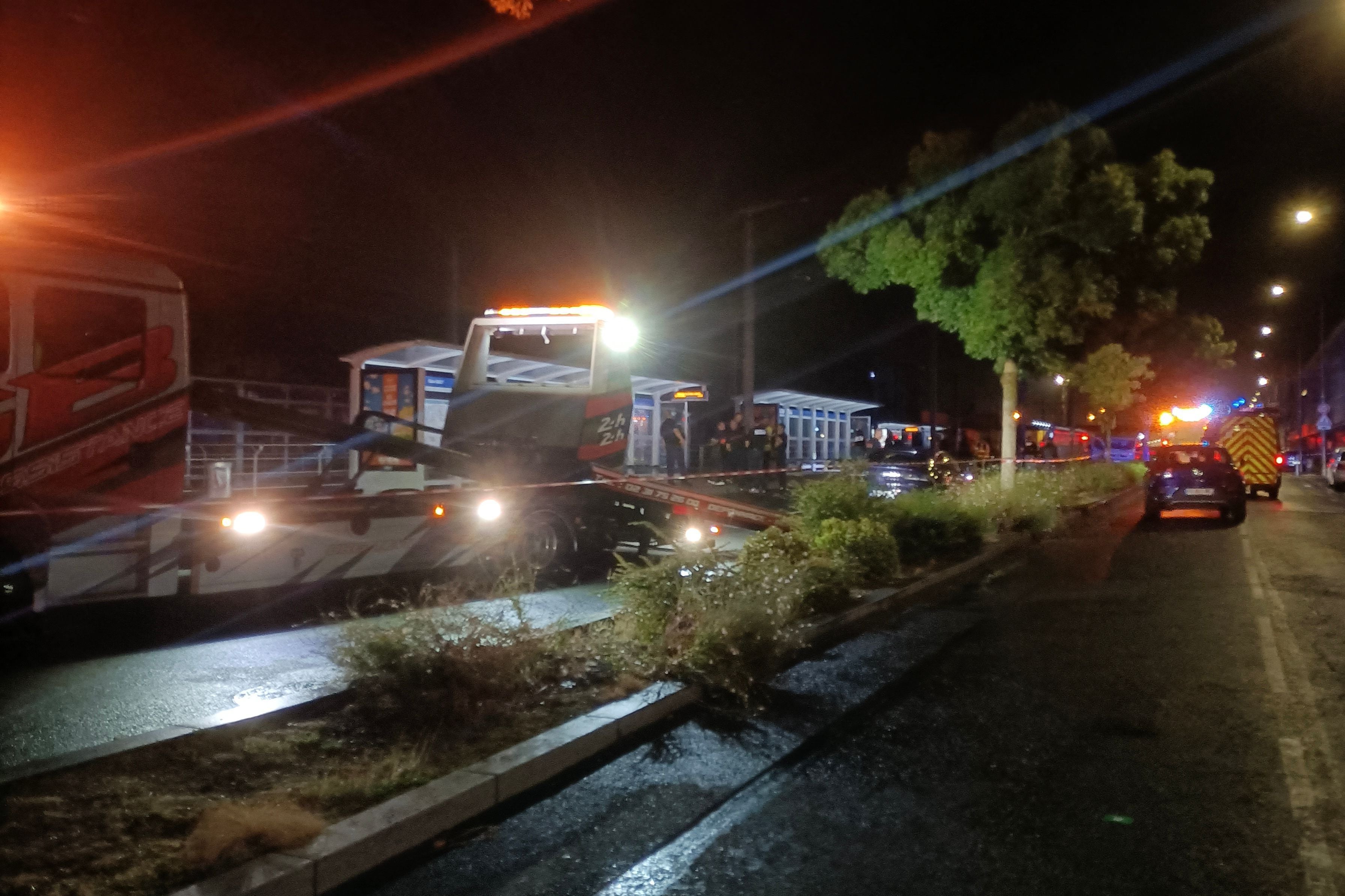 Polizei und Rettungskräfte nachts an einem Unfallort mit Abschleppwagen und Absperrband in Caen.