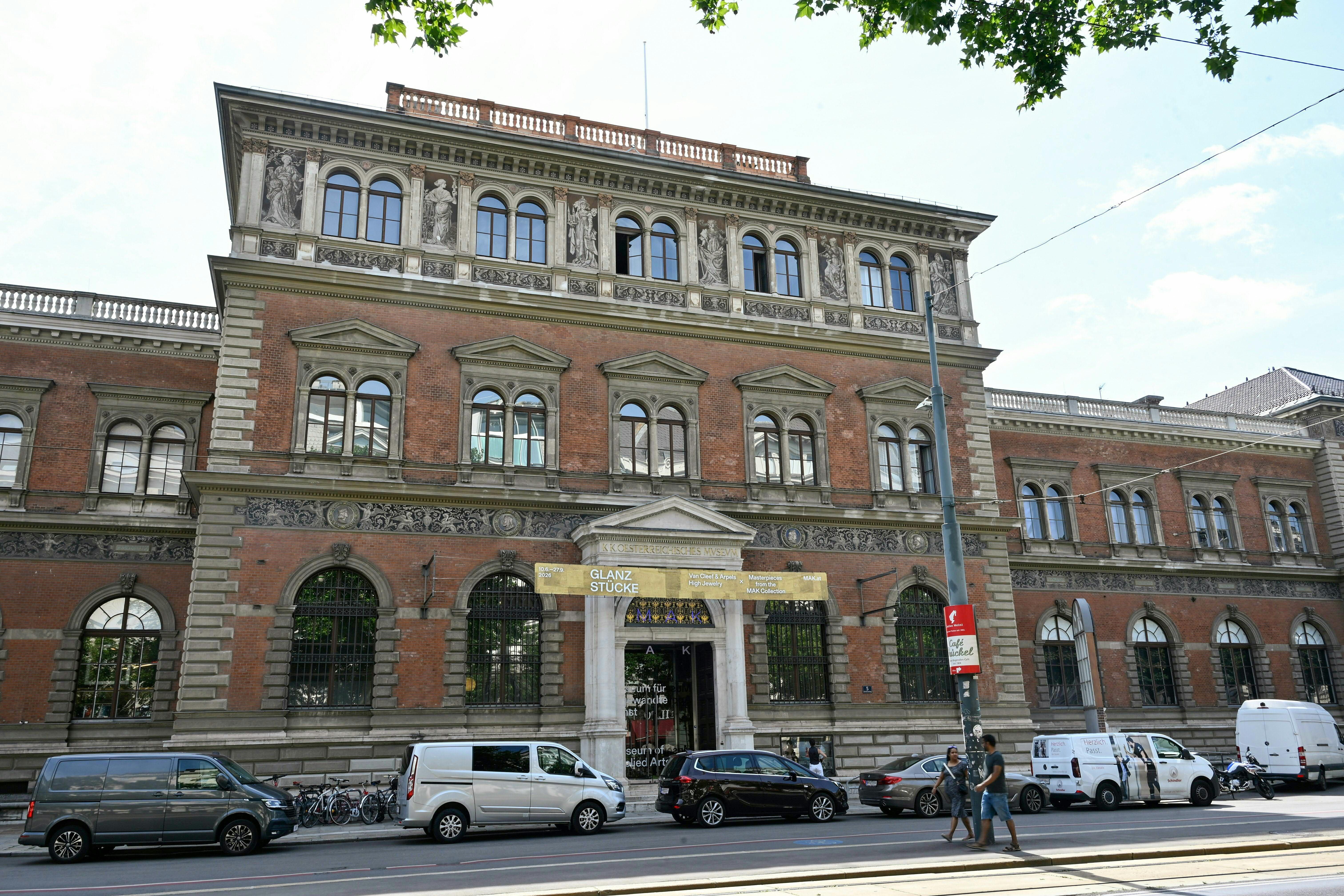 Außenansicht des Museum für Angewandte Kunst (MAK) in Wien mit Autos und Passanten davor.