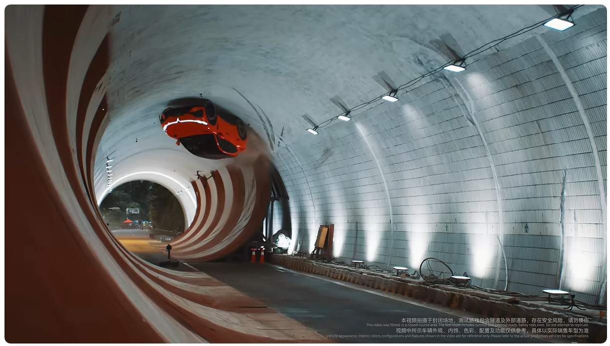 Ein rotes Auto fährt kopfüber an der Wand eines beleuchteten Tunnels entlang.