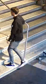 Eine Person geht eine Treppe hinauf, neben ihr ein Rollstuhl auf dem Boden.