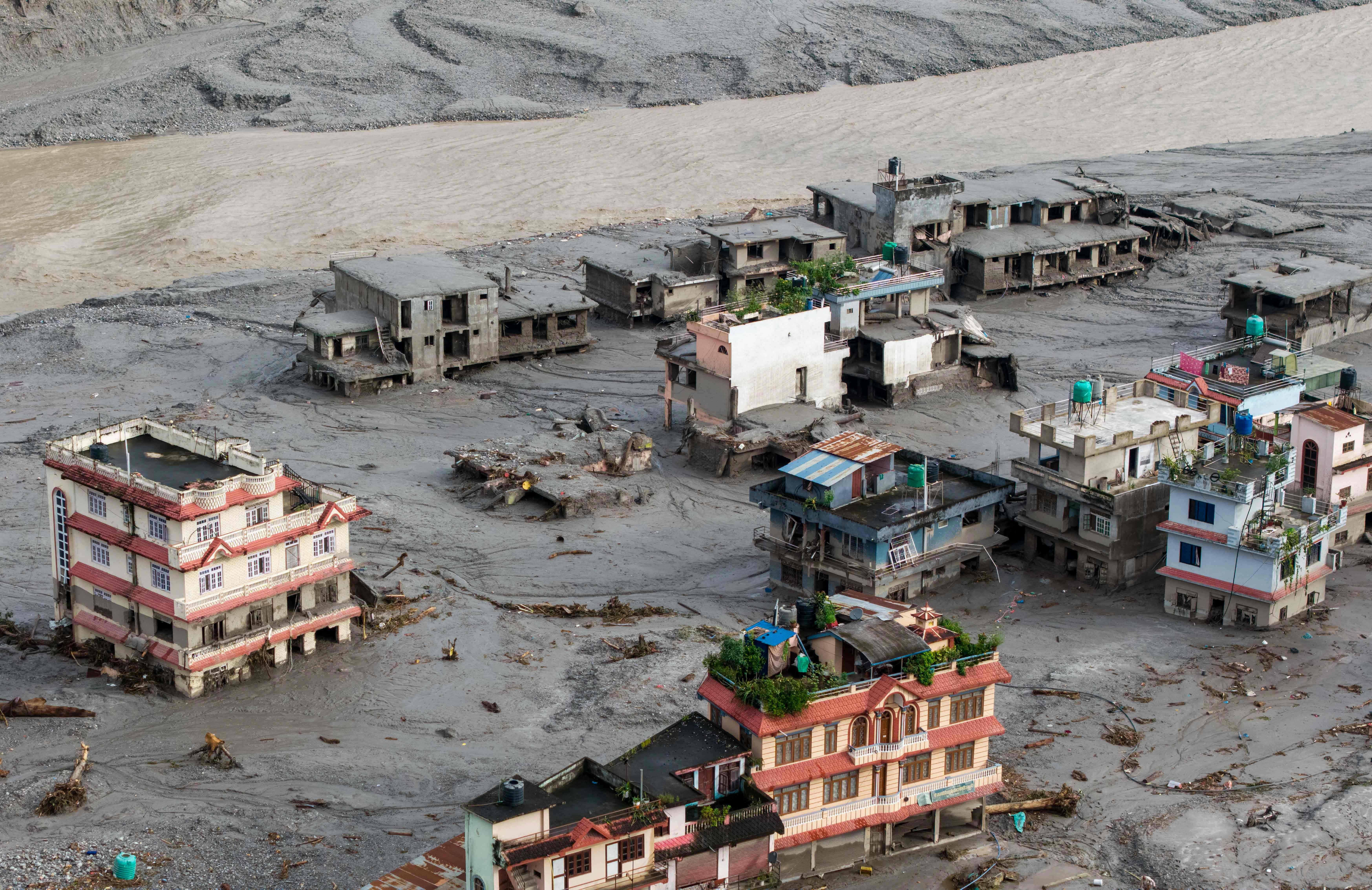 Luftaufnahme von überfluteten und beschädigten Häusern nach Sturzfluten in Devighat, Nepal.