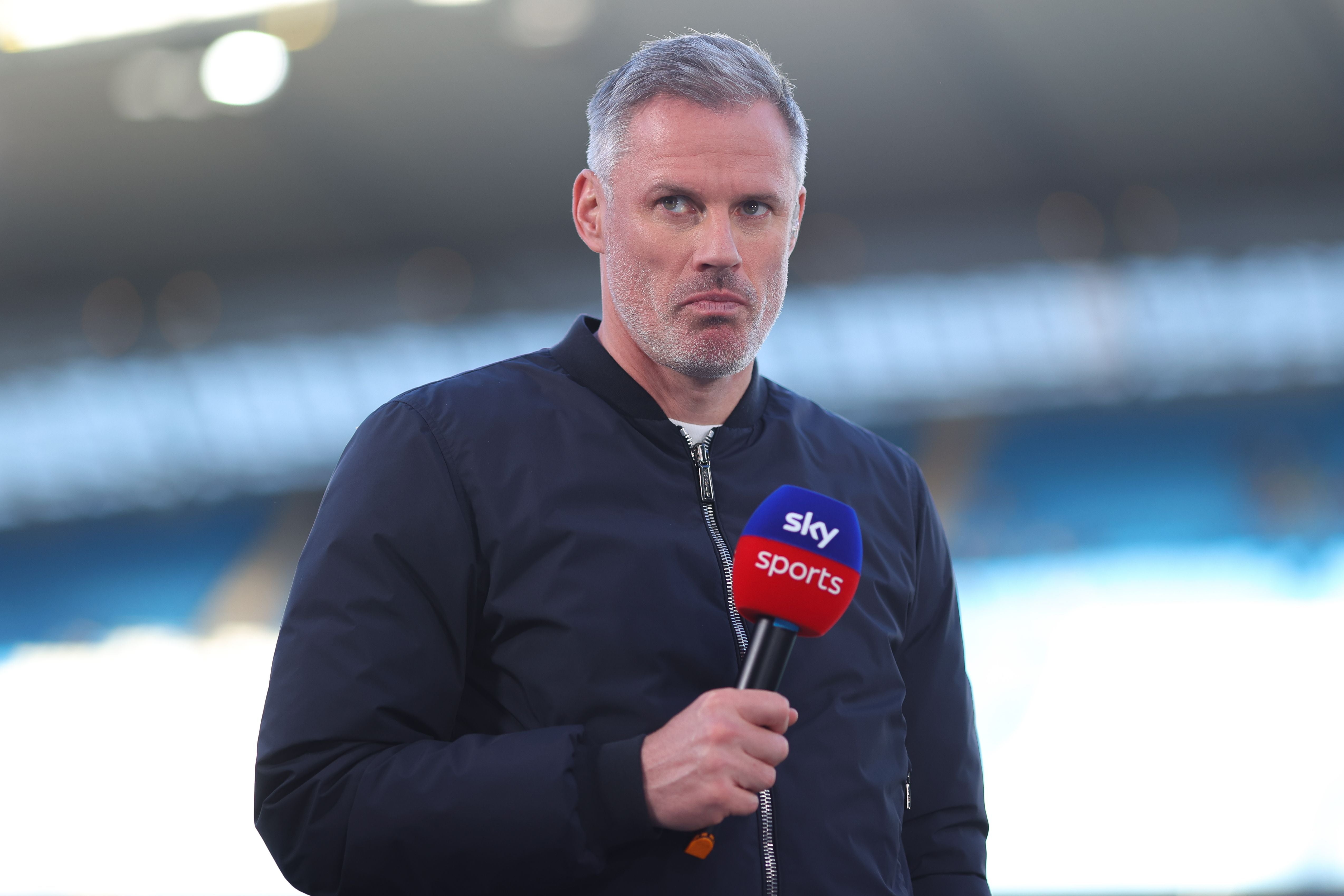 Ein Mann mit Mikrofon von Sky Sports steht im Stadion und blickt ernst in die Kamera.