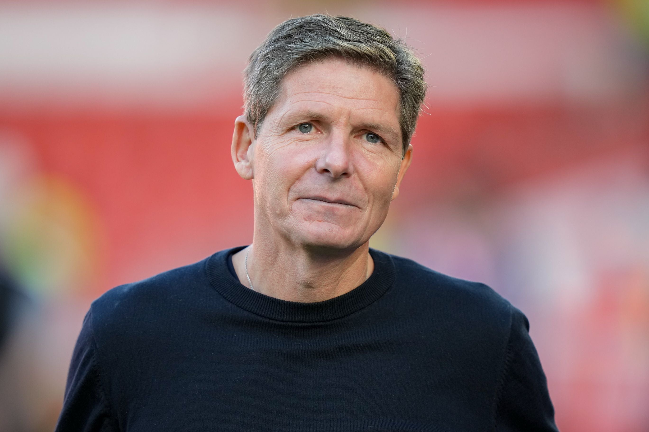 Ein Mann mit kurzen Haaren und dunklem Pullover blickt leicht lächelnd in die Kamera.