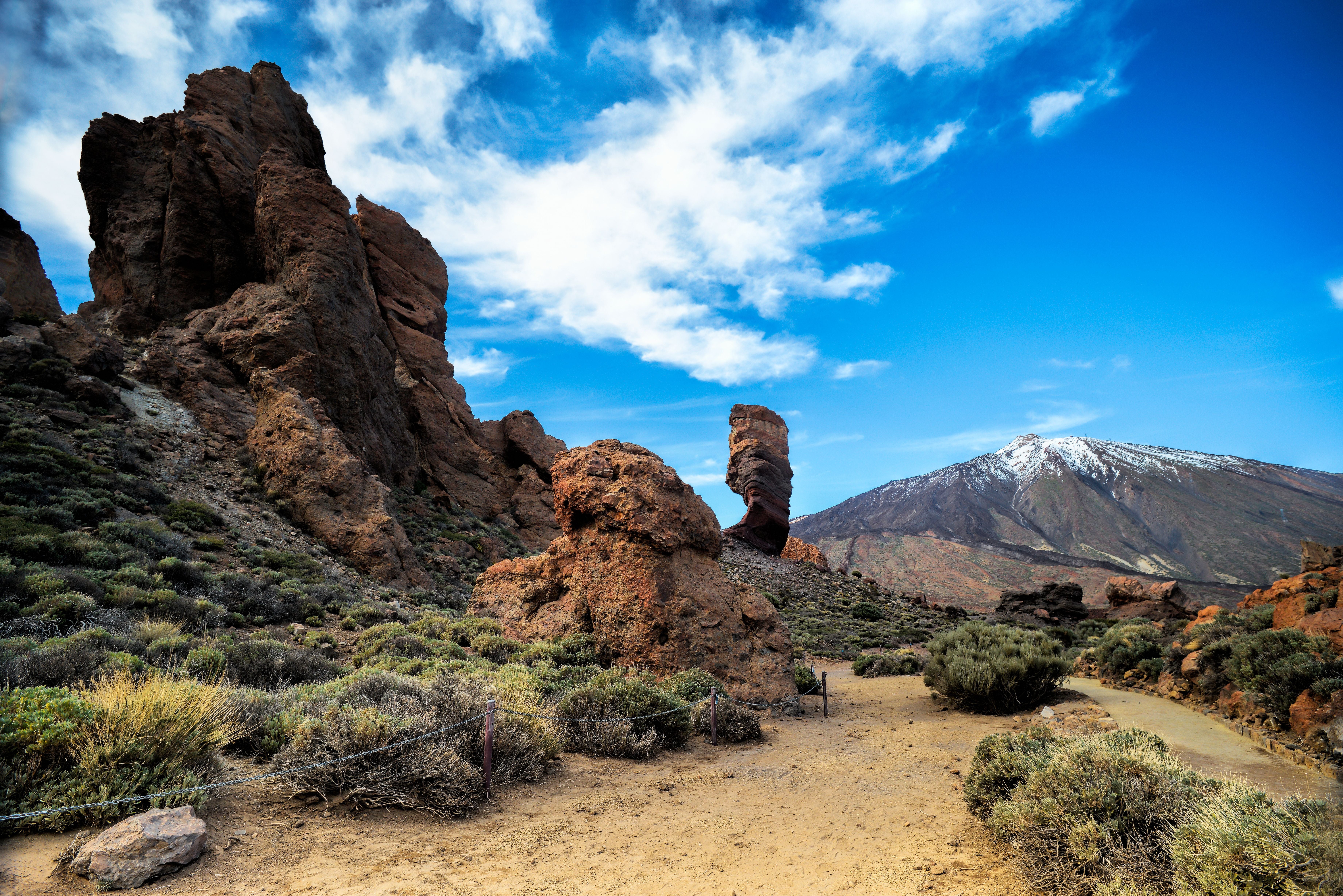 Felsformationen und Wanderweg mit Blick auf den schneebedeckten Teide auf Teneriffa.