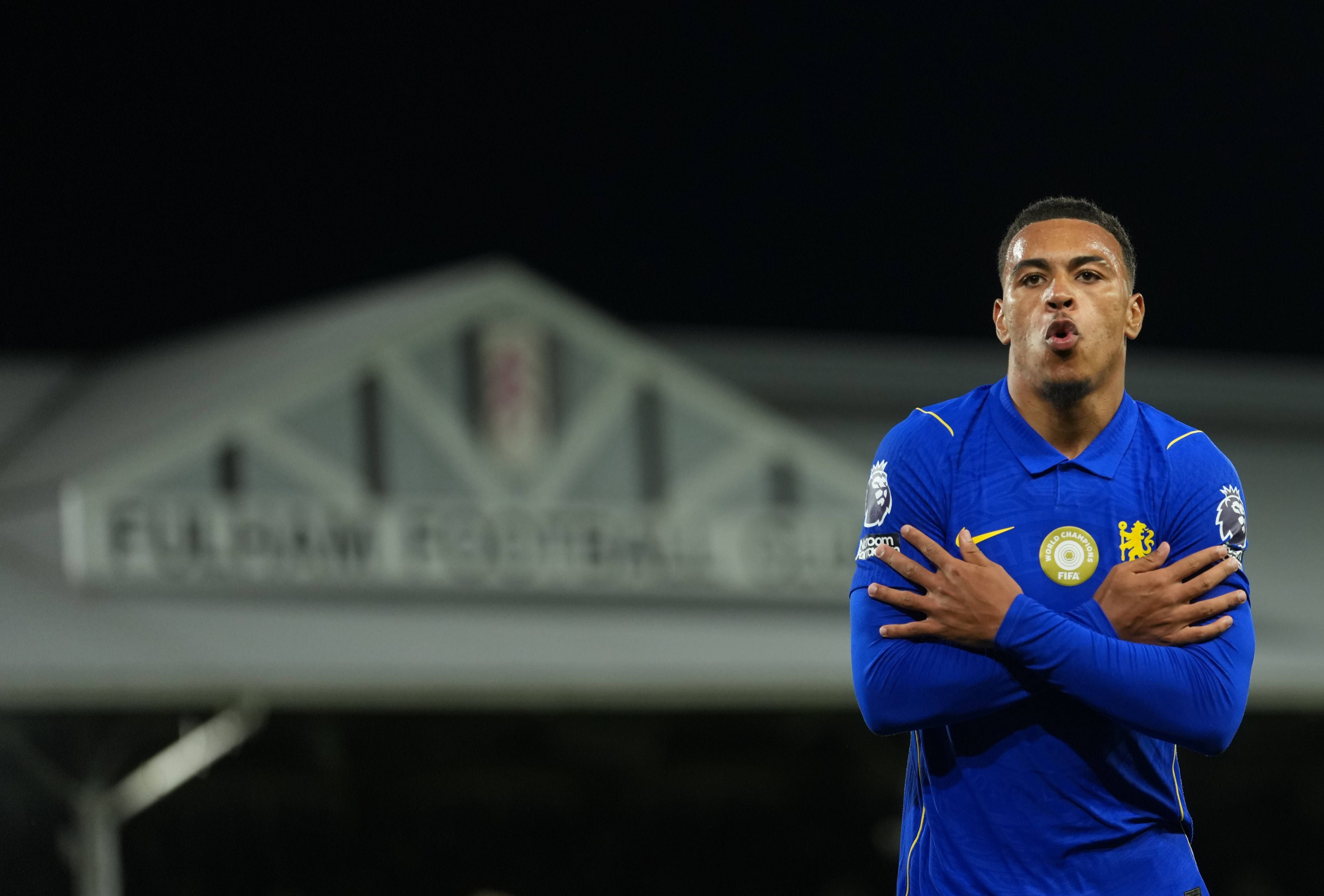 Ein Chelsea-Spieler im blauen Trikot jubelt mit verschränkten Armen im Stadion Craven Cottage.