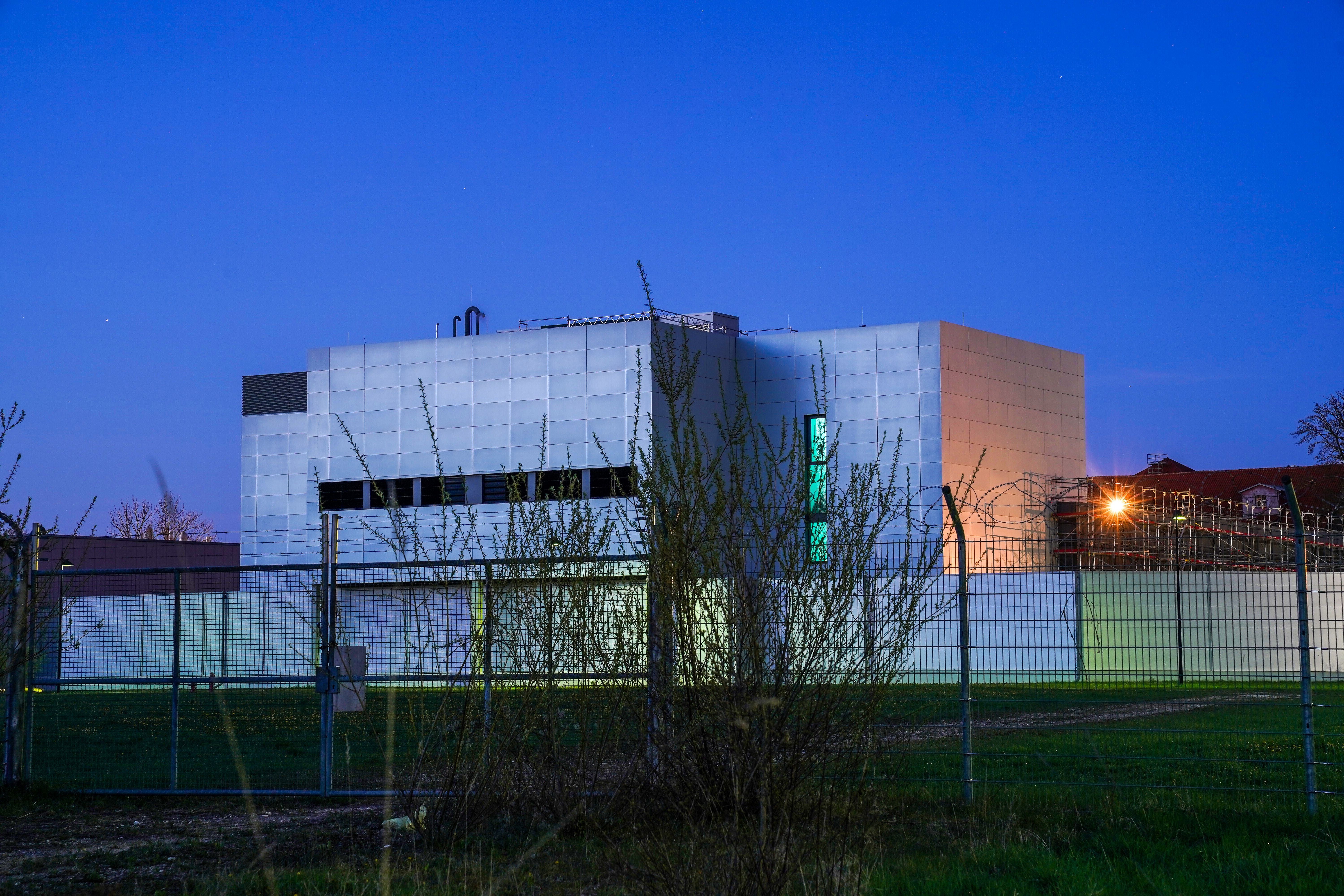 Moderne Produktionsanlage mit Metallfassade und Zaun, aufgenommen bei Abenddämmerung in Illertissen.