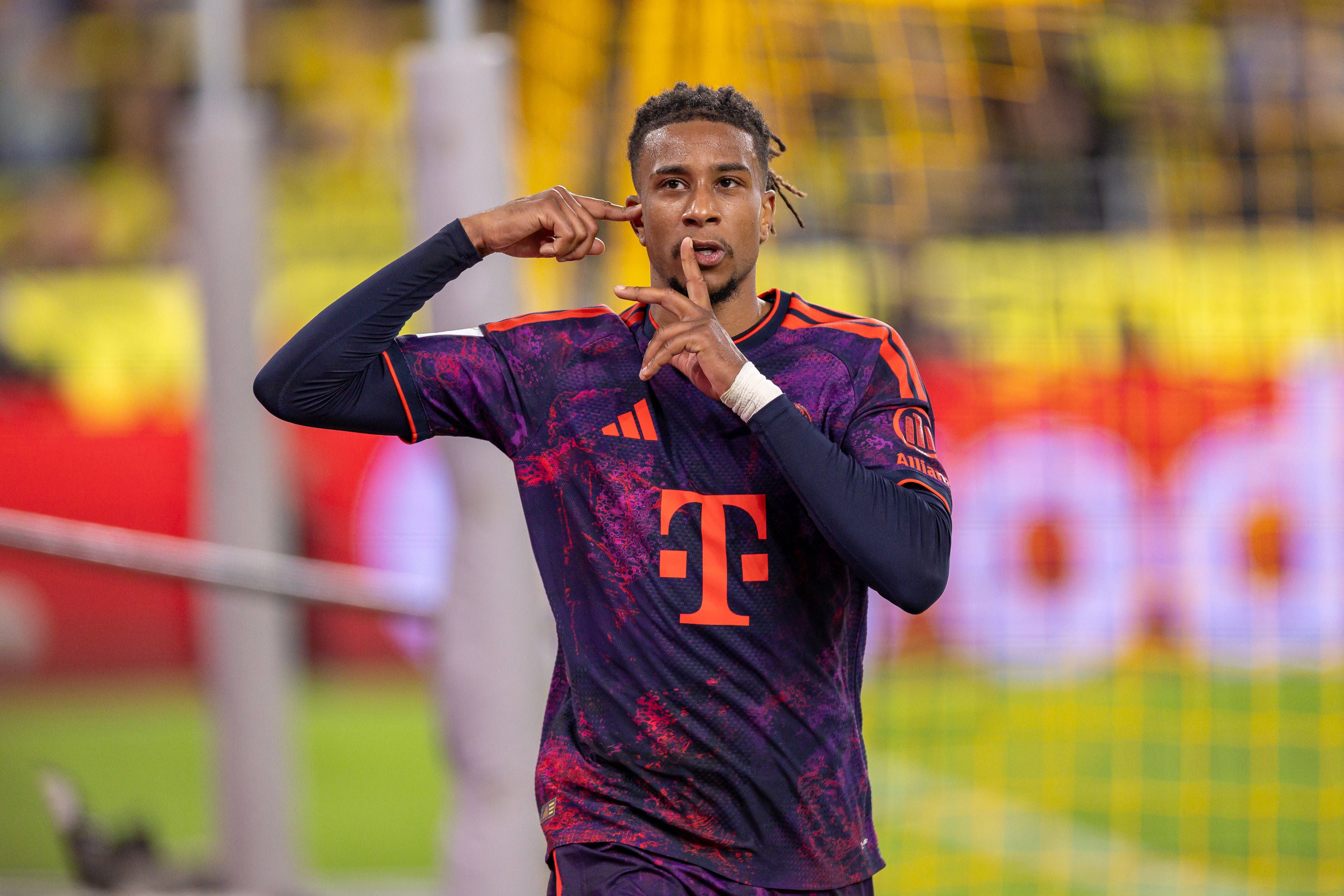Fußballspieler im FC Bayern Trikot jubelt mit Geste nach einem Tor im Stadion.