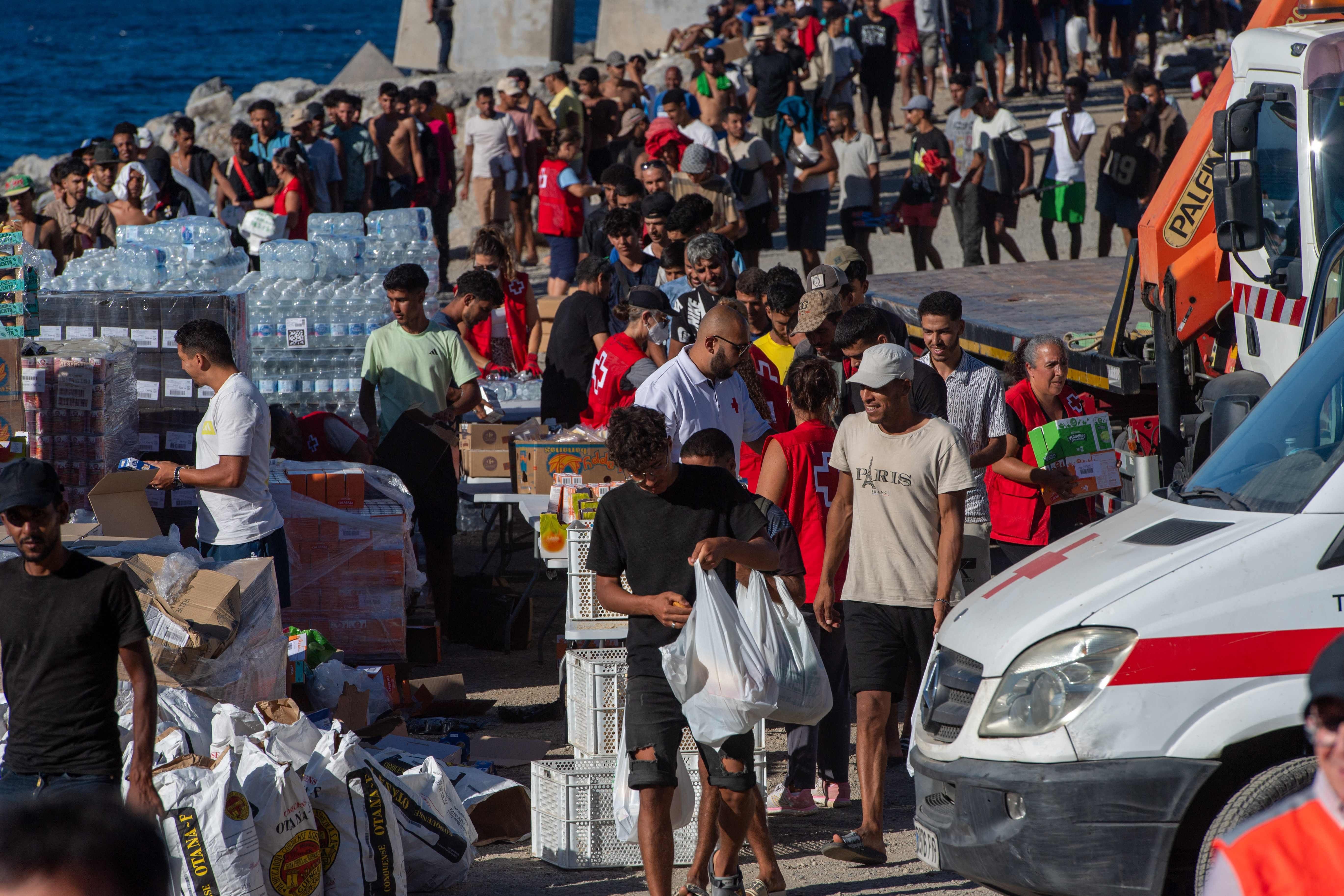 Migranten stehen am 28. August am Strand El Trampolin in Ceuta für eine Essensausgabe des Roten Kreuzes an.