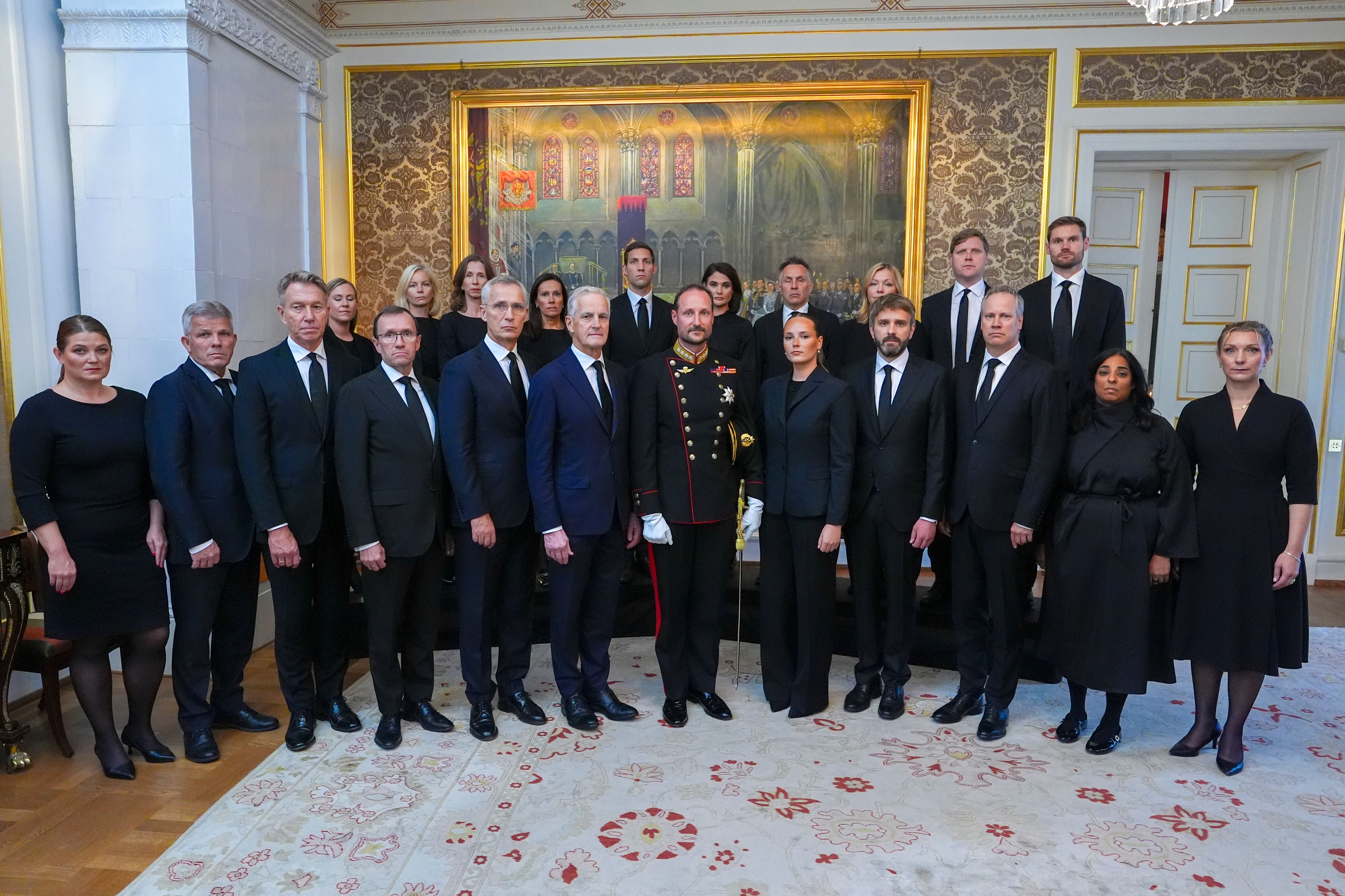 Gruppenfoto von Personen in formeller Kleidung im prunkvollen Raum eines Palastes.