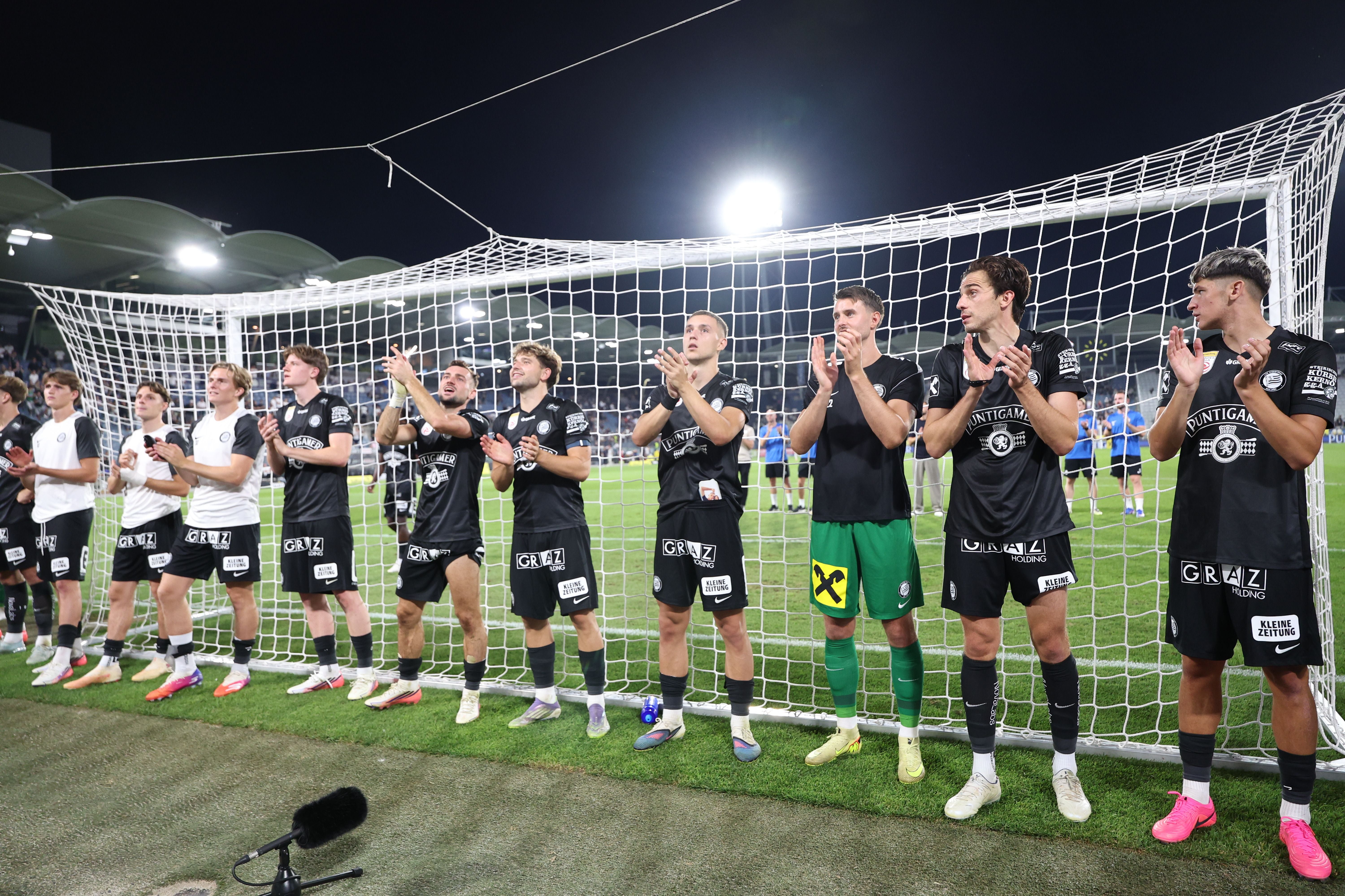 Spieler von Sturm Graz jubeln vor dem Tor und applaudieren nach einem Fußballspiel.