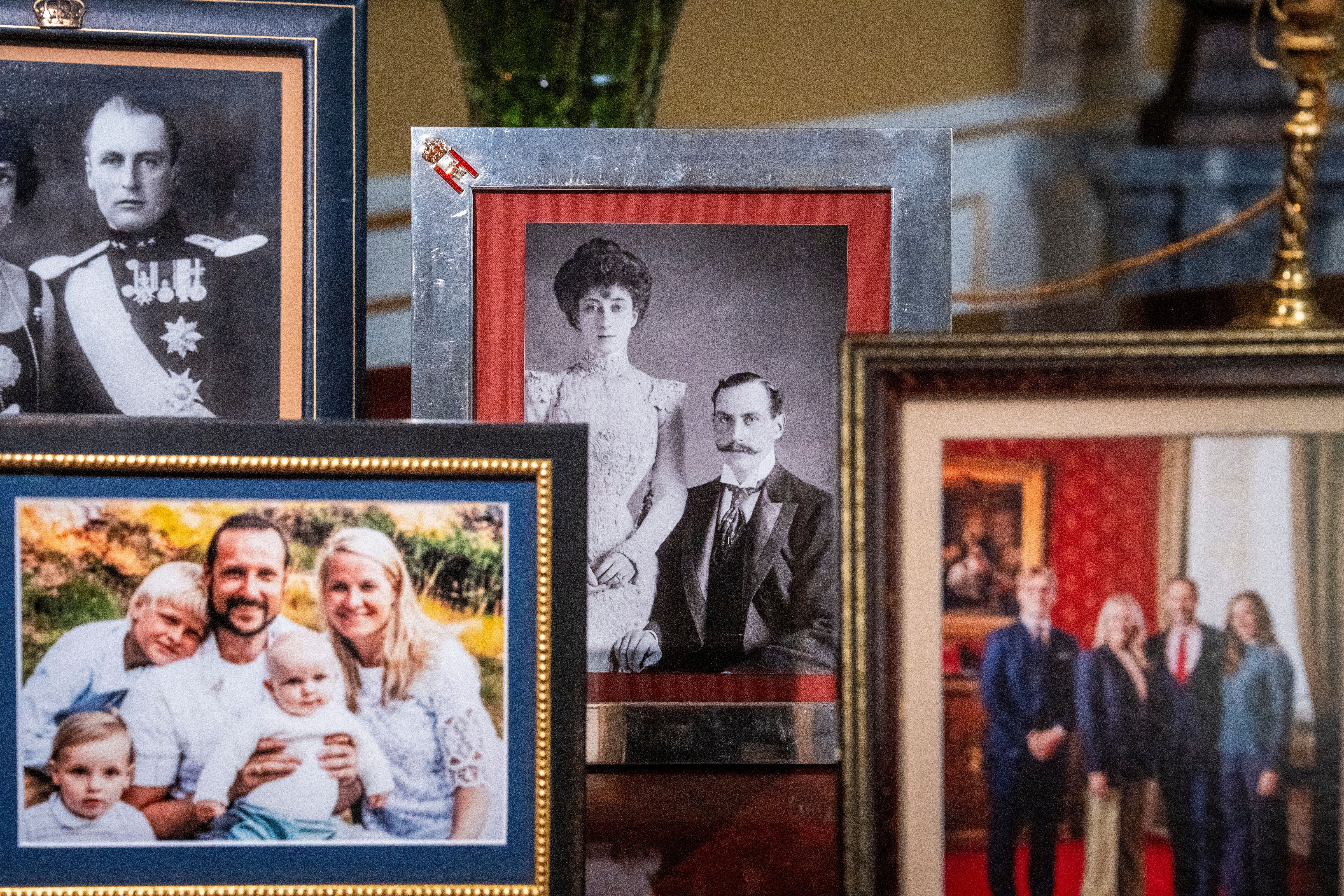 Mehrere gerahmte Familienfotos, teils historisch, auf einem Tisch arrangiert.