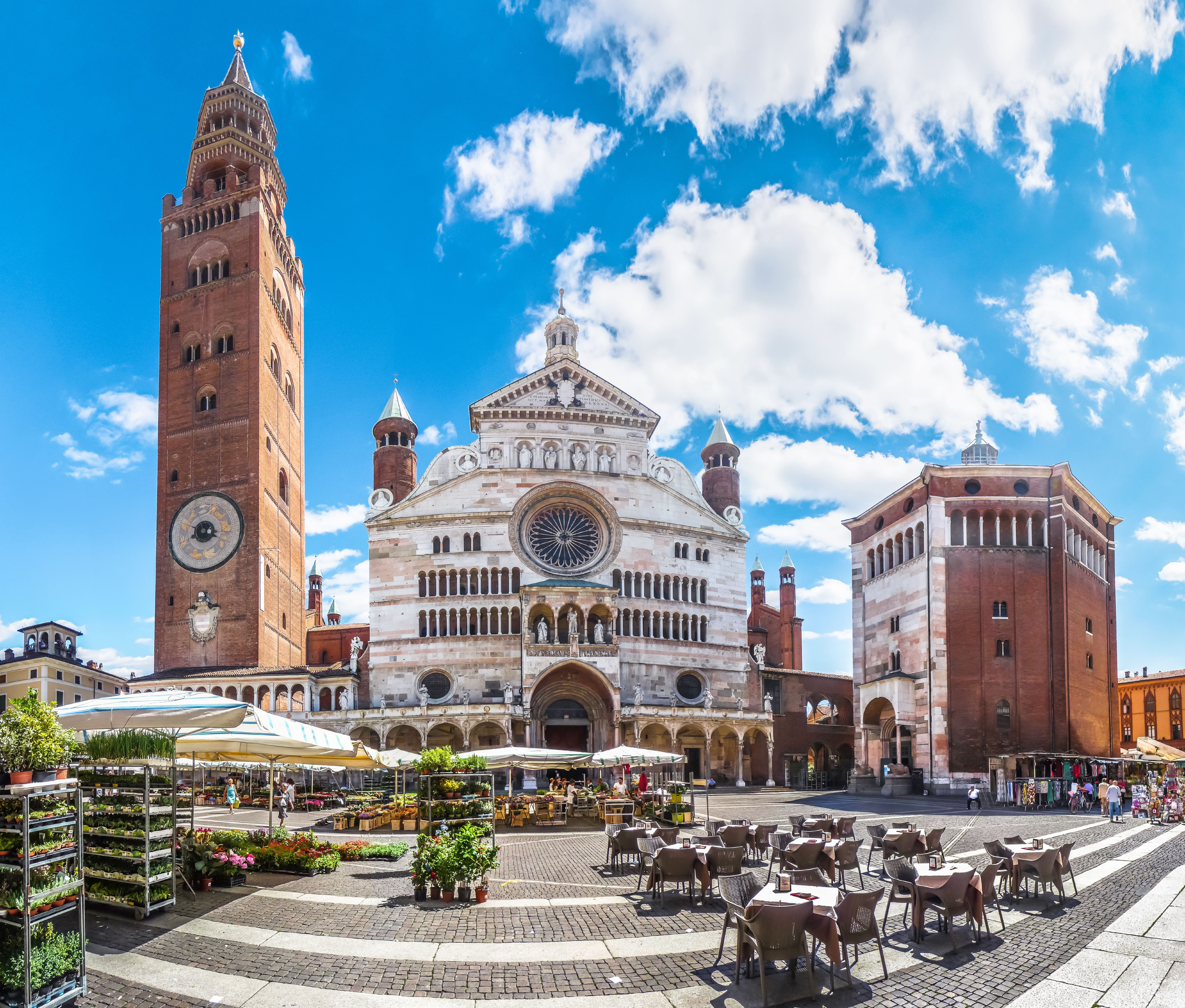Der Dom von Cremona mit dem Torrazzo und dem Baptisterium an der Piazza Duomo bei blauem Himmel.