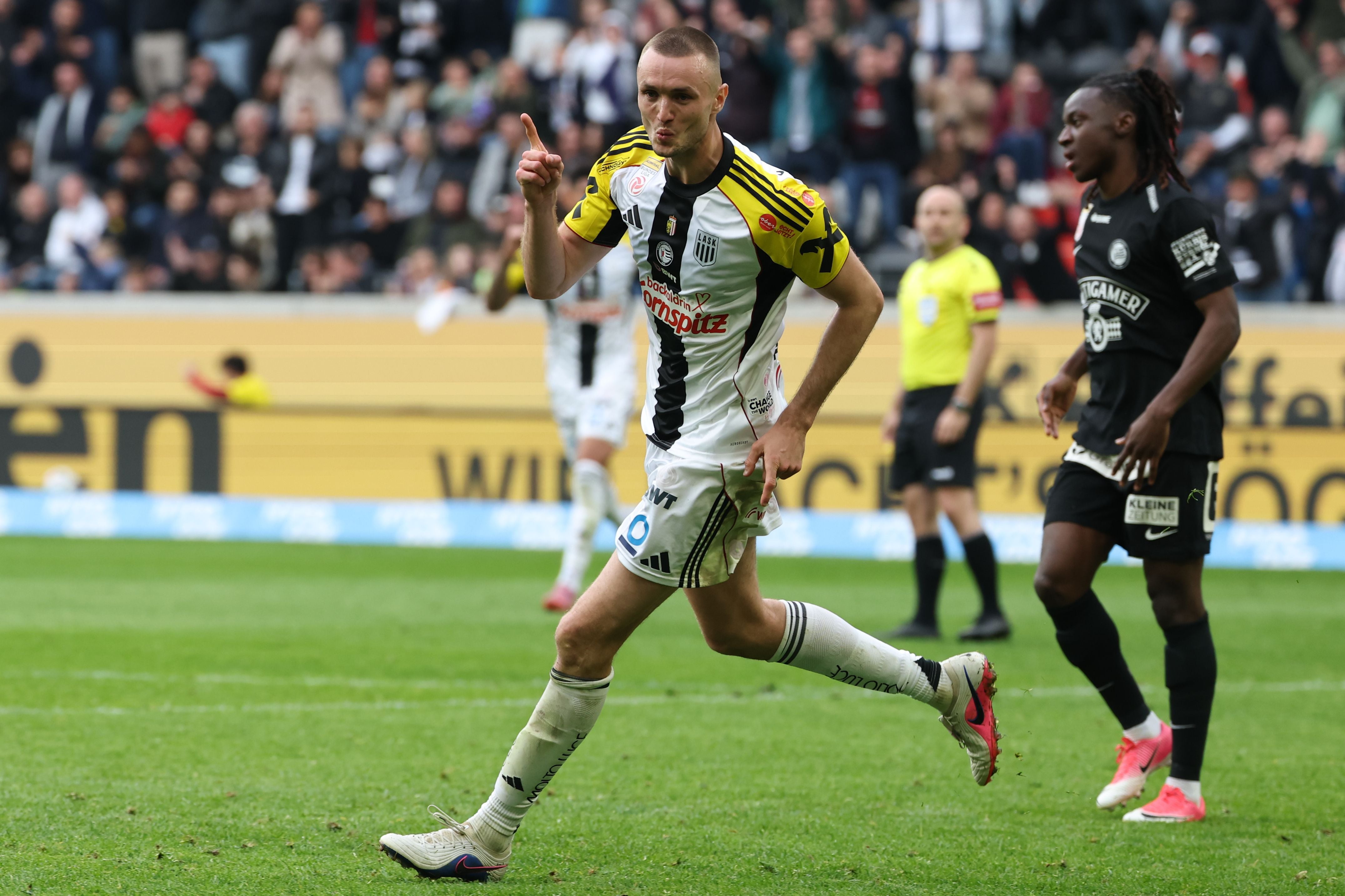 Ein Fußballspieler von LASK jubelt nach einem Tor auf dem Spielfeld.