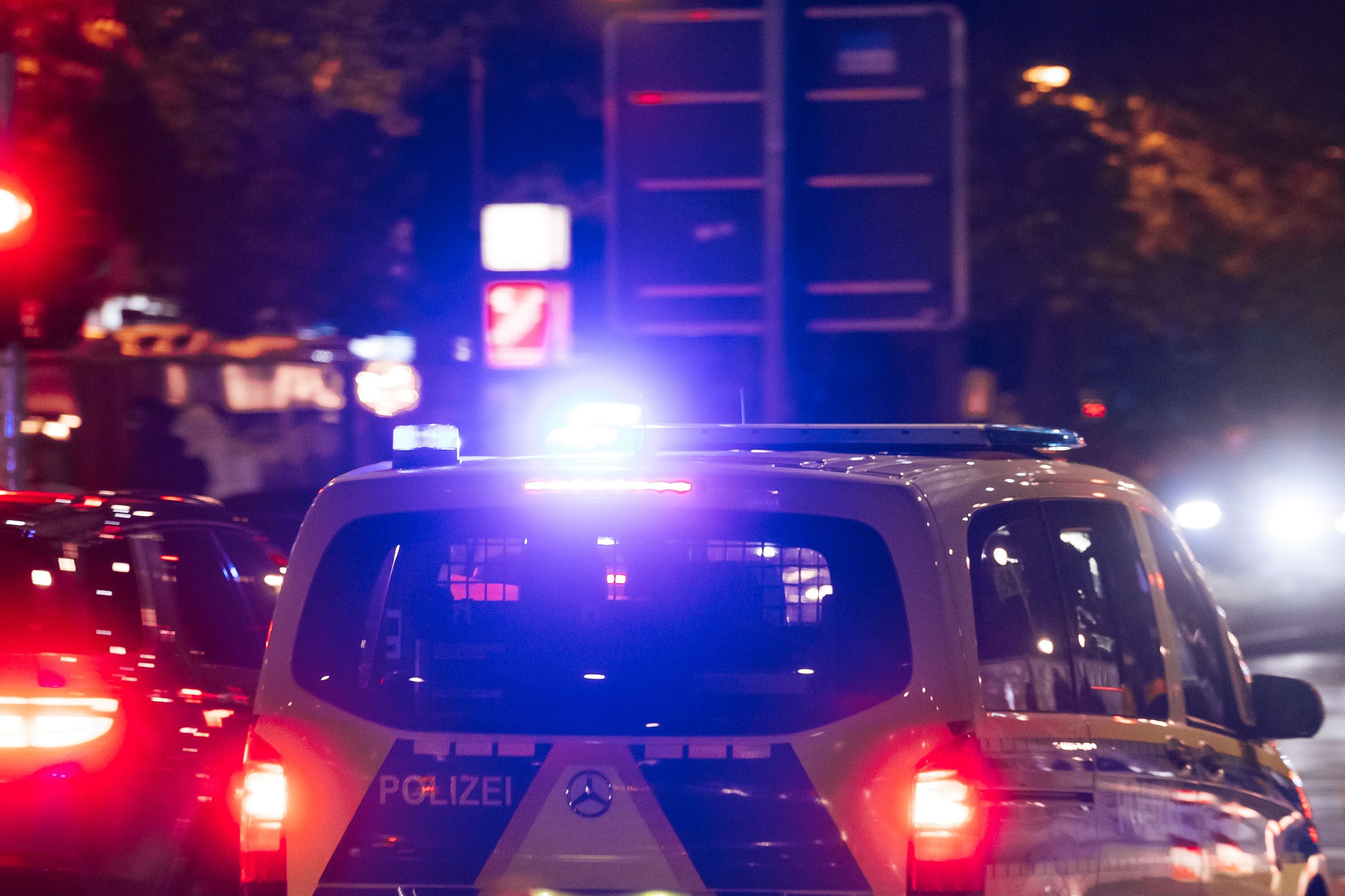 Ein Polizeiauto mit Blaulicht fährt abends durch den Berliner Stadtverkehr.