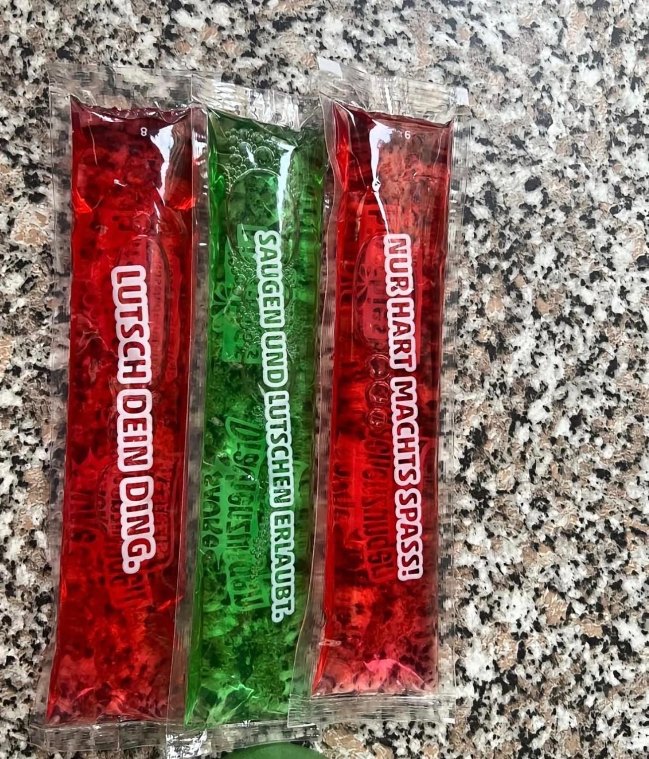 Drei Wassereis mit zweideutigen Sprüchen auf einer grauen Marmorplatte.
