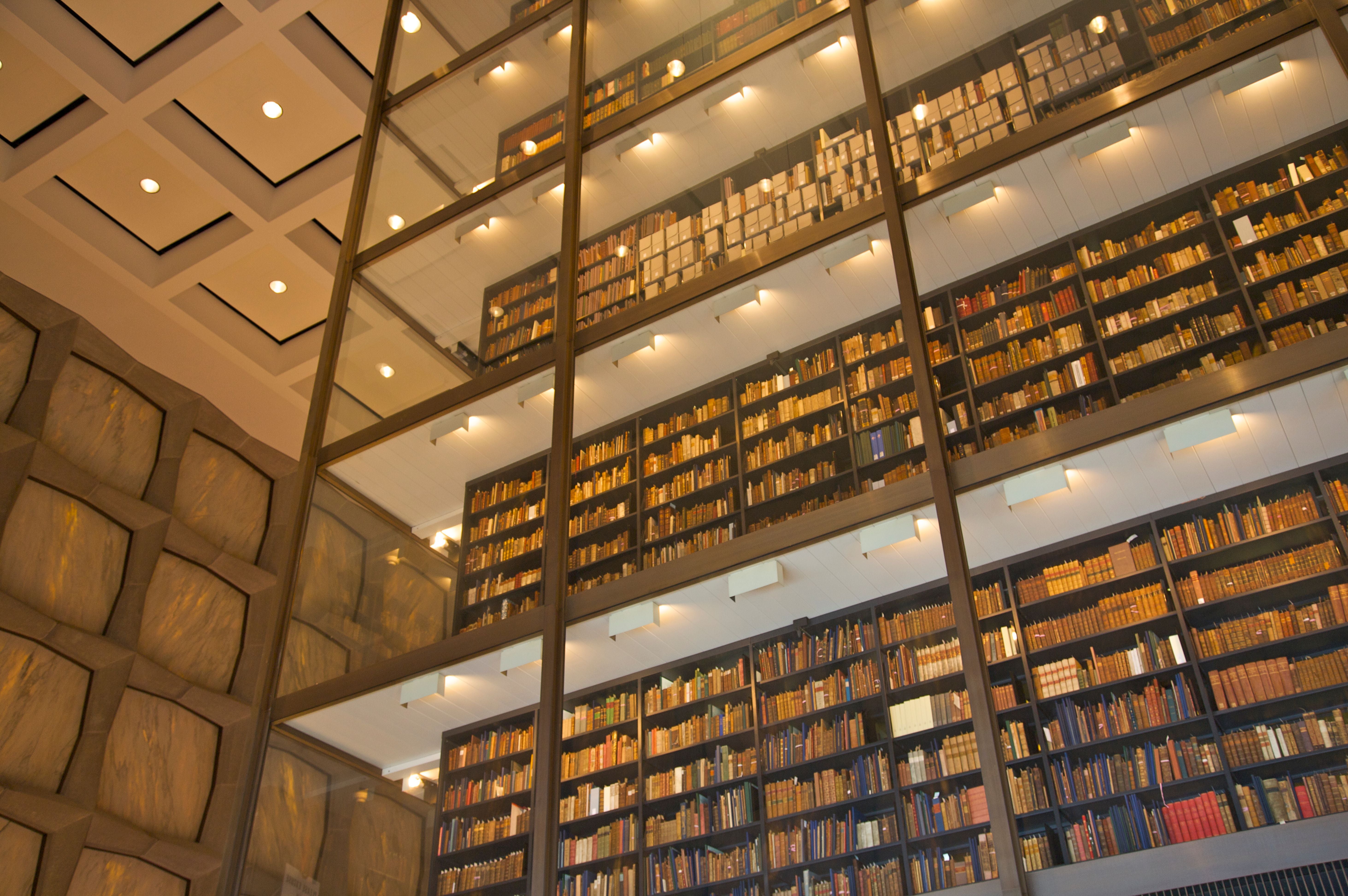 Mehrstöckige Bibliothek mit beleuchteten Regalen voller Bücher, moderne Architektur.
