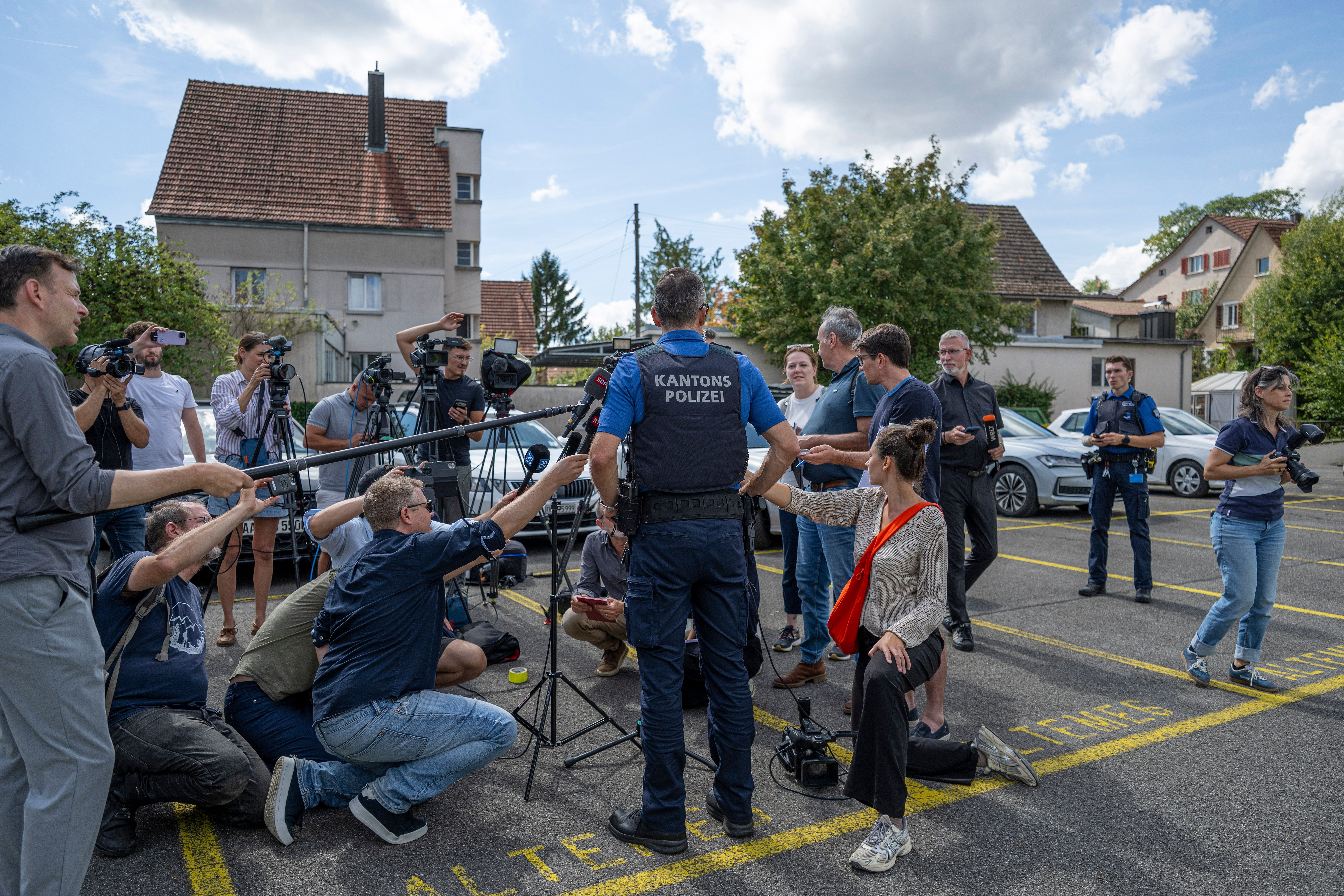 Ein Polizeisprecher gibt im Freien eine Pressekonferenz vor Reportern und Kamerateams.