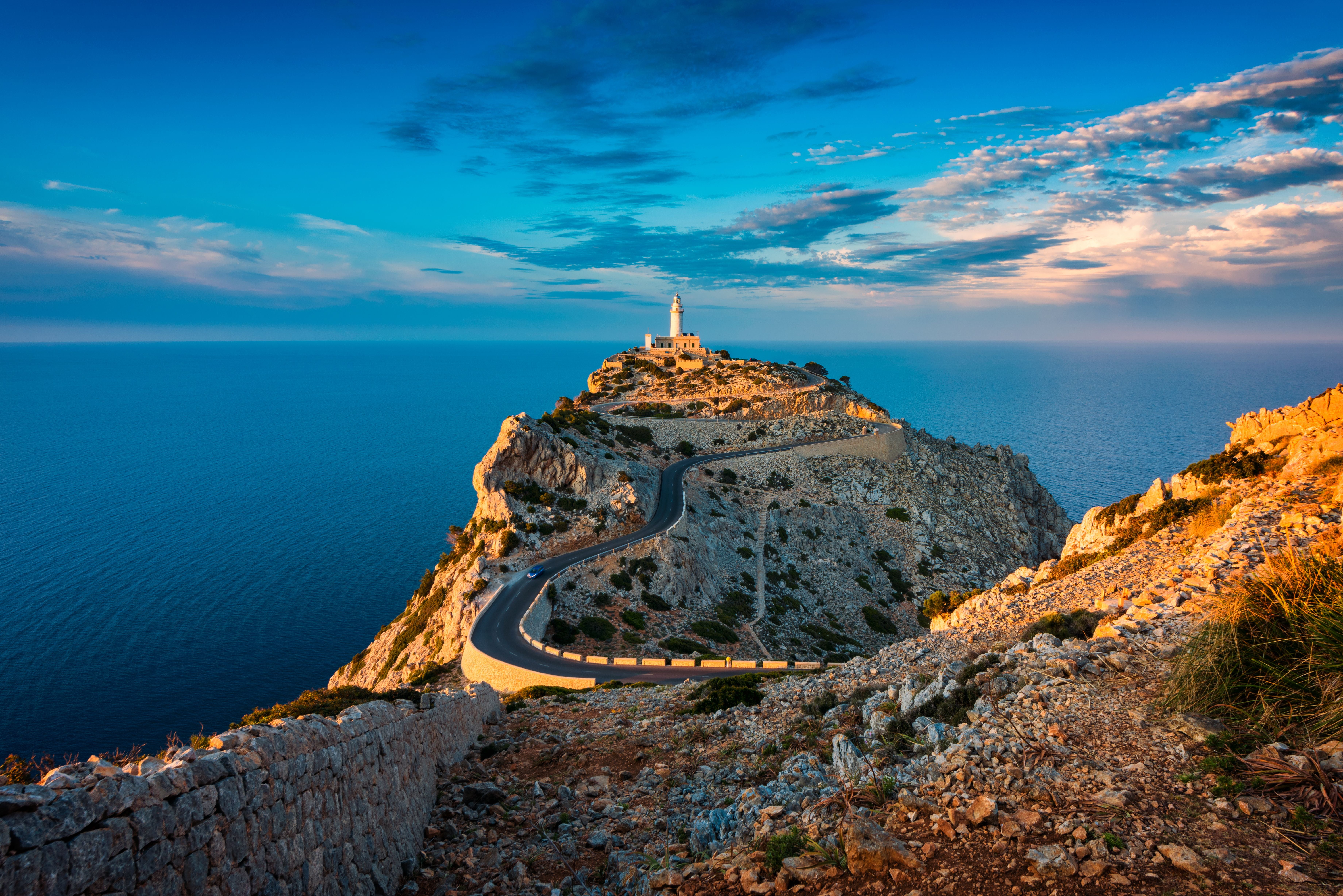 Leuchtturm auf dem Cap de Formentor auf Mallorca, umgeben von Meer bei Sonnenuntergang.