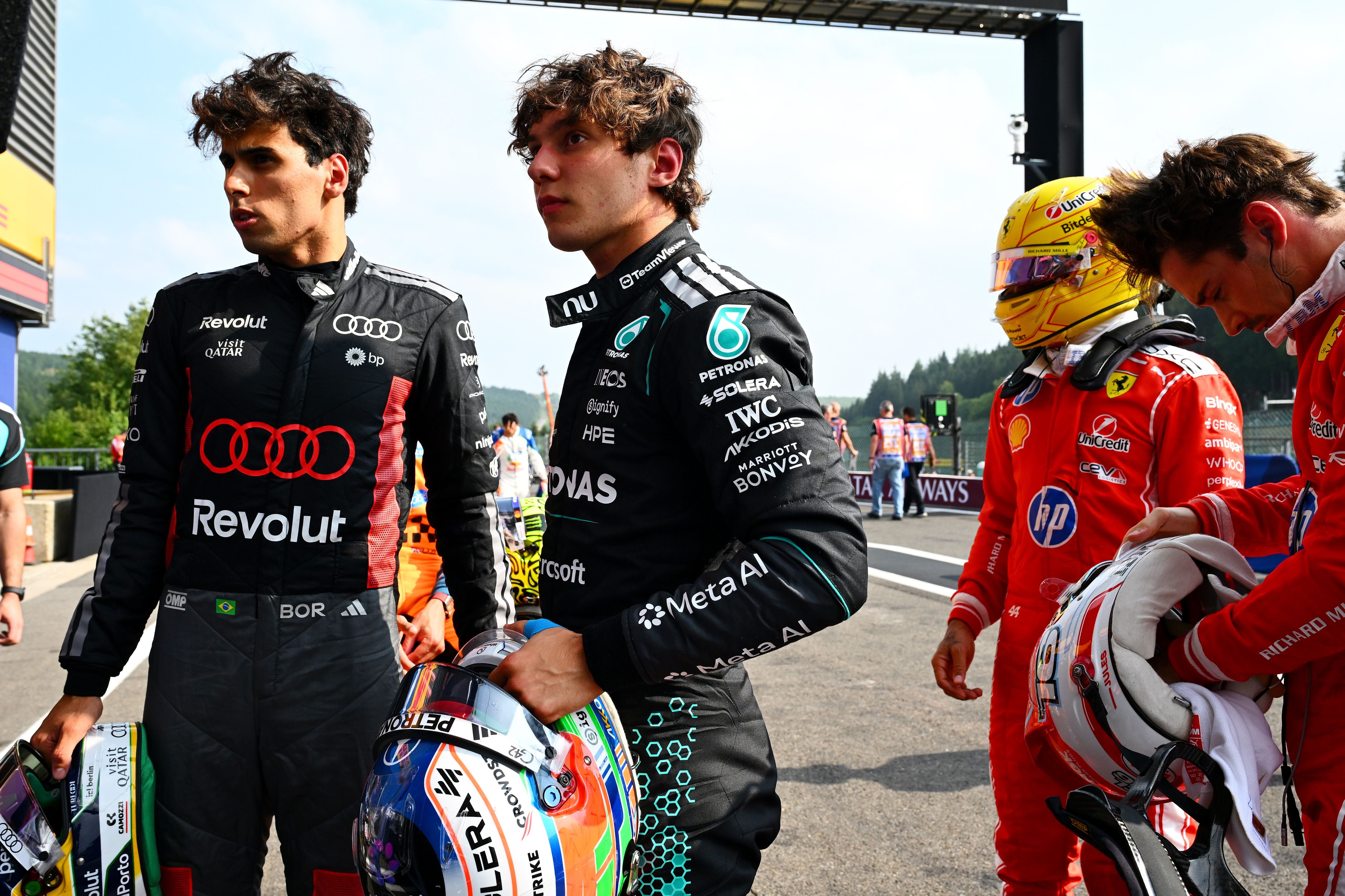 Vier Formel-1-Fahrer stehen nach dem Qualifying auf der Strecke und halten ihre Helme.