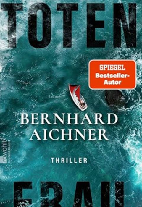 Buchcover von "Totenfrau" mit Meeresansicht, schwarzem Text und kleinem Segelboot.