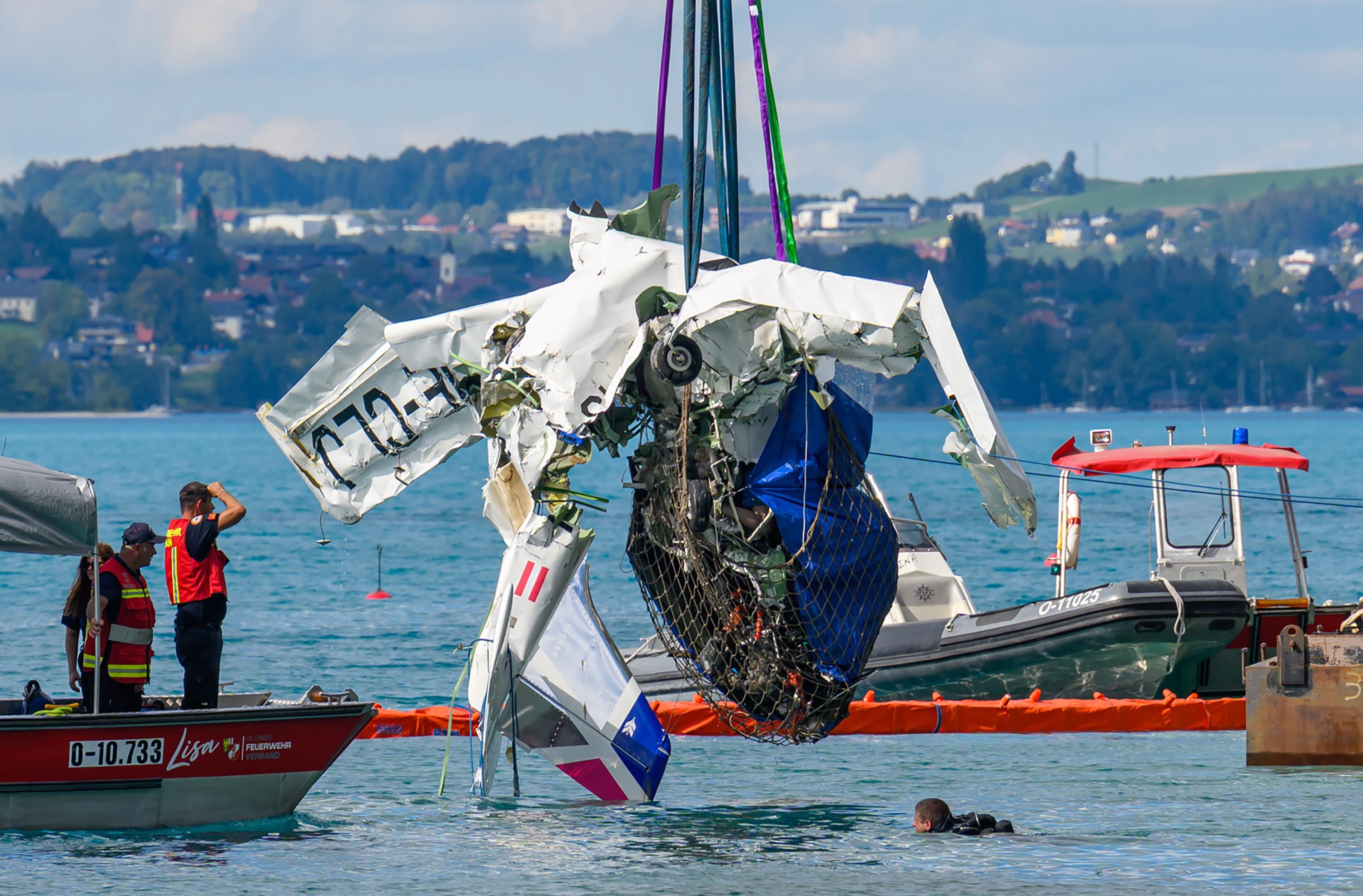 Bergung eines abgestürzten Propellerflugzeugs aus dem Attersee durch Einsatzkräfte und Taucher.