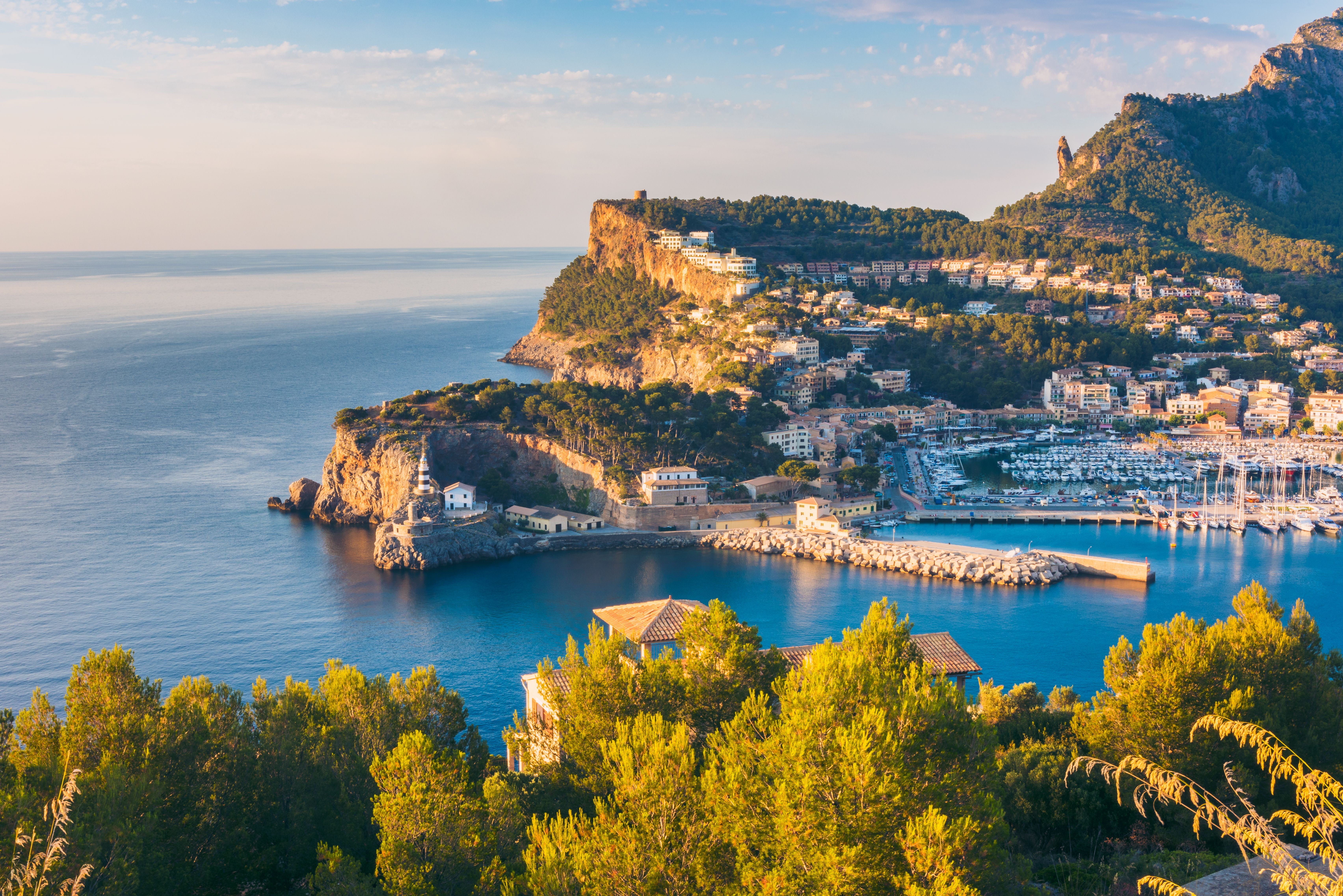 Hafen von Port de Sóller auf Mallorca mit Bergen und Meer im Sonnenuntergang.