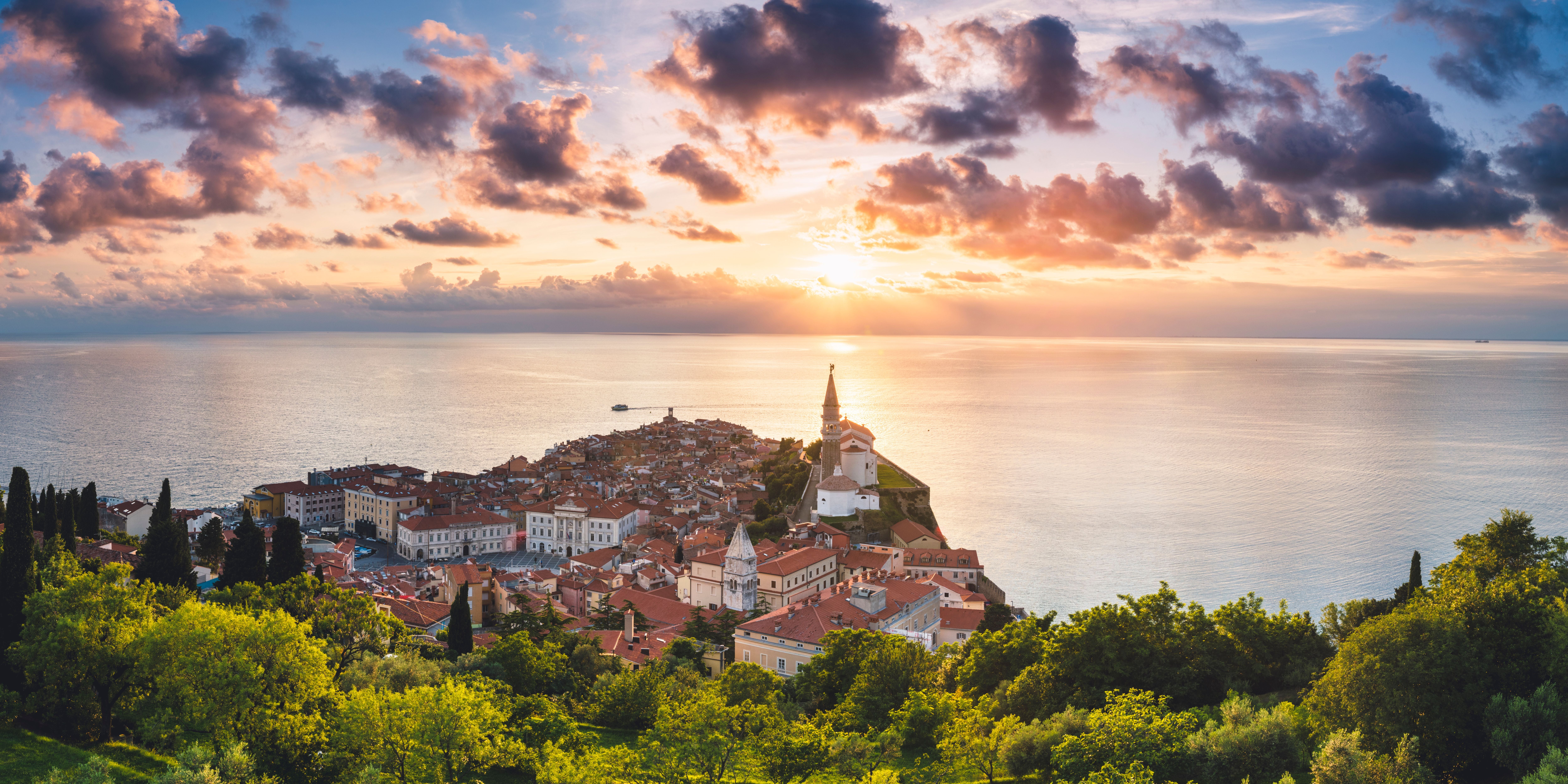 Blick auf Piran in Slowenien bei Sonnenuntergang mit Meer und historischer Altstadt.