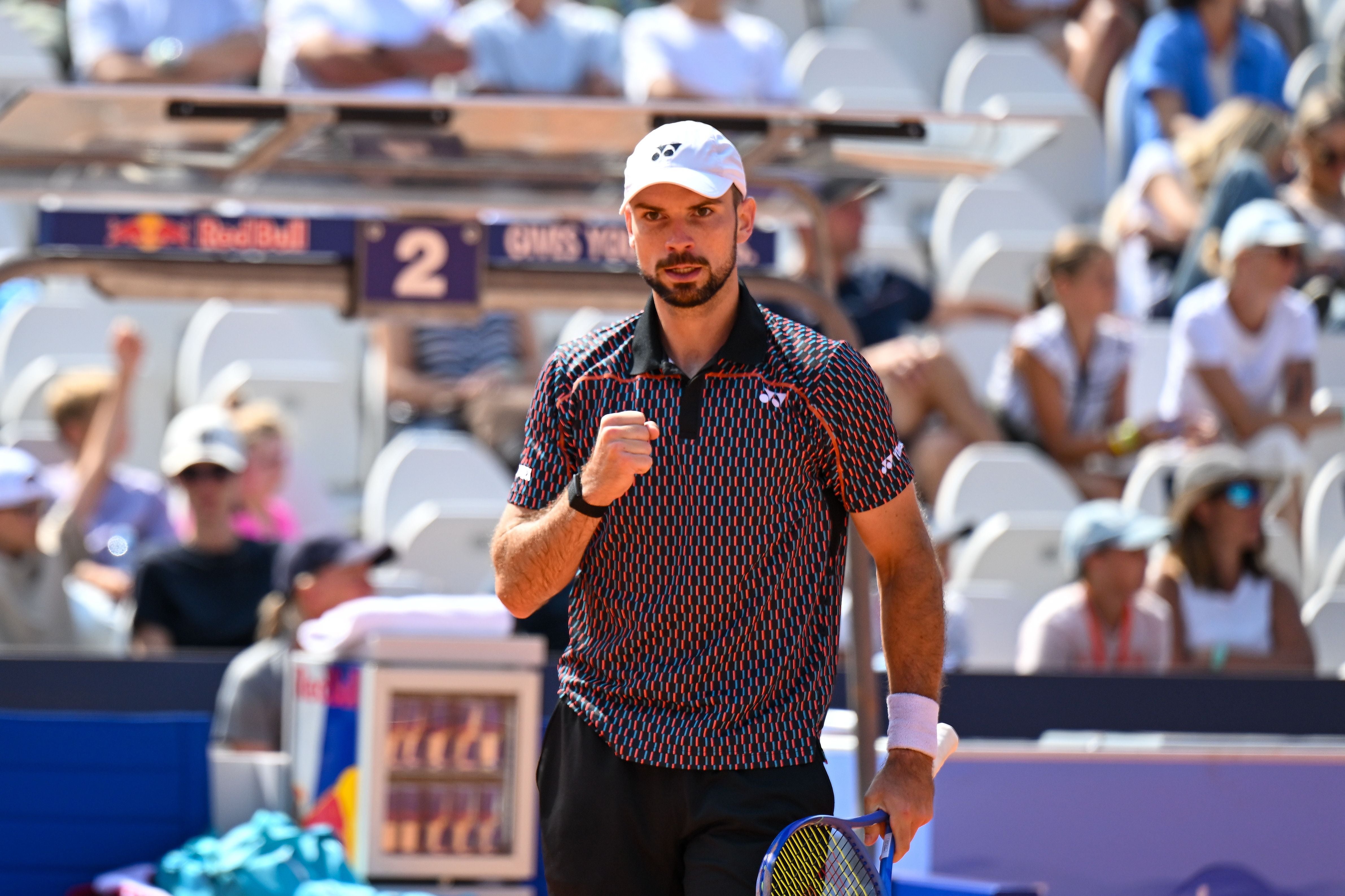 Ein Tennisspieler ballt die Faust auf dem Platz vor jubelndem Publikum.