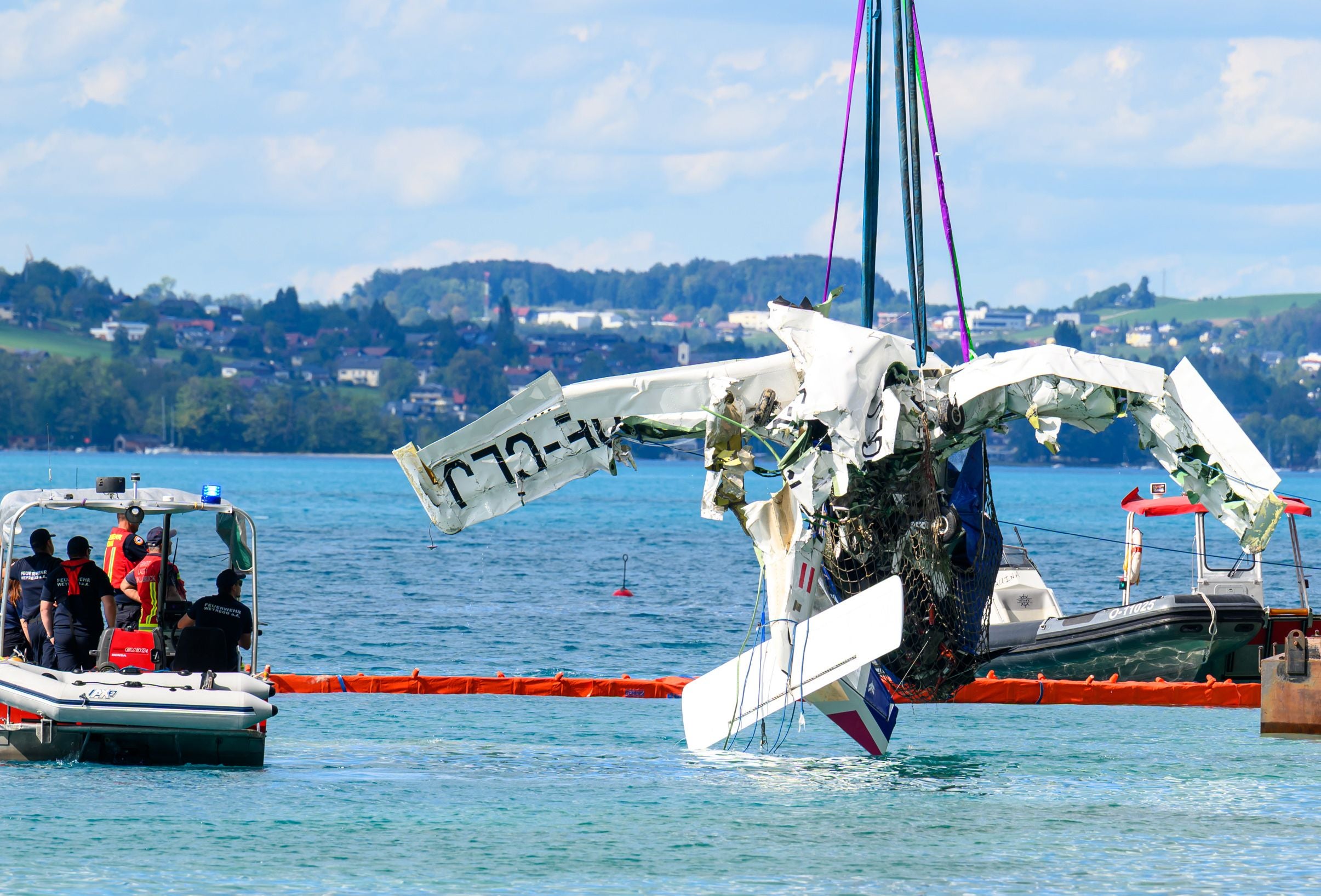 Bergung eines abgestürzten Propellerflugzeugs aus dem Attersee durch Einsatzkräfte auf Booten.