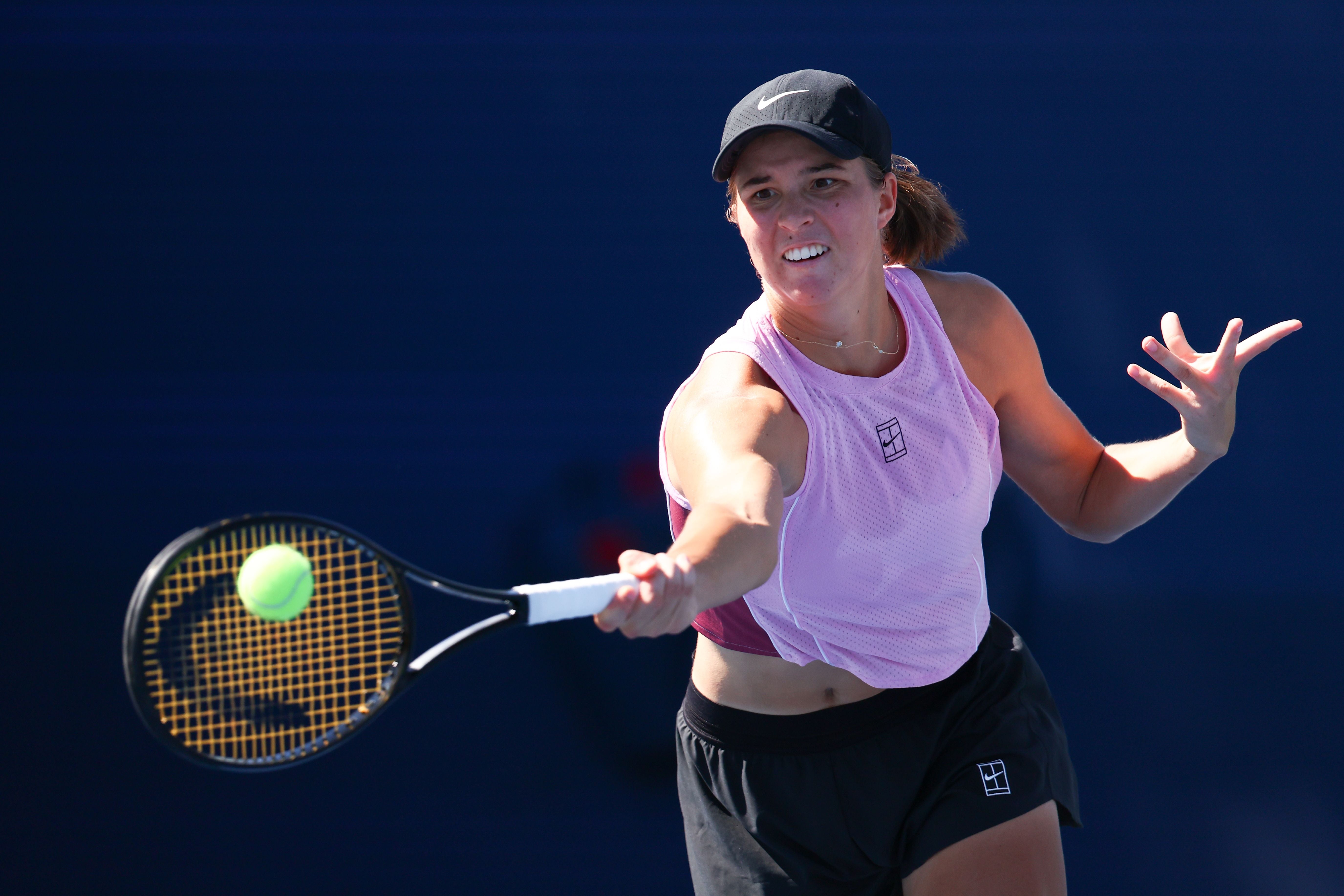 Eine Tennisspielerin schlägt den Ball bei einem Training auf dem Tennisplatz.