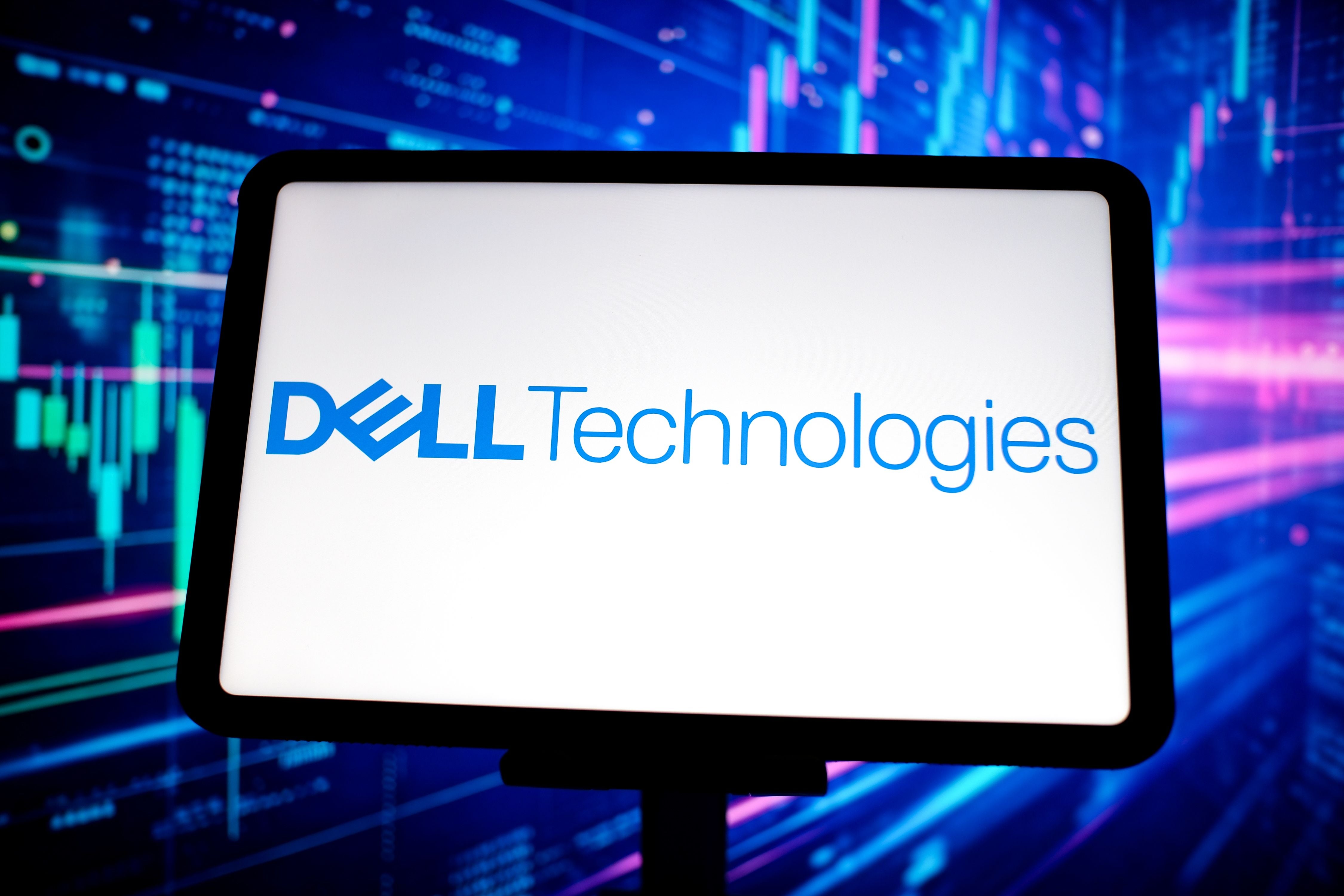 Das Dell Technologies Logo ist auf einem Tablet vor Börsendiagrammen zu sehen.